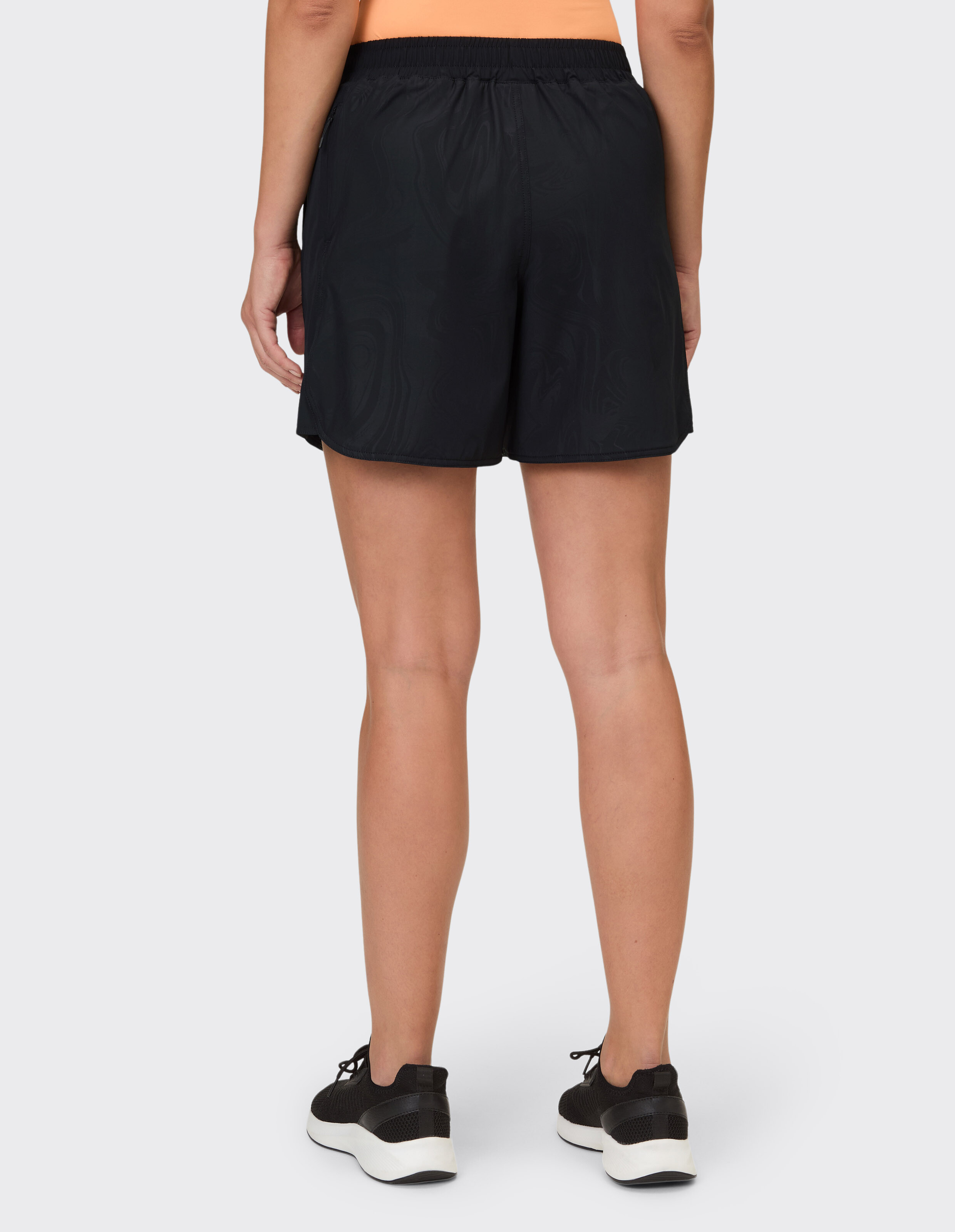 Rückansicht einer Frau in schwarzen Freizeitshorts, perfekt für den aktiven Einsatz.