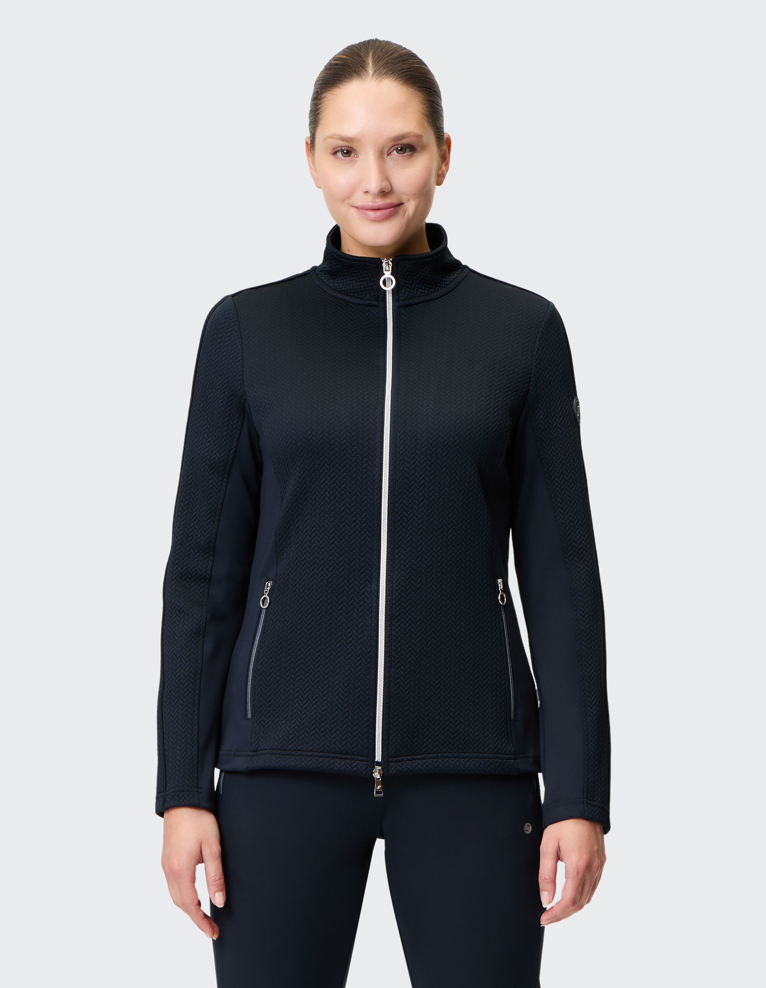 Dunkelblaue Damenjacke mit Reißverschluss, Stehkragen und zwei Fronttaschen, aus strukturiertem Stoff mit dezentem Muster.