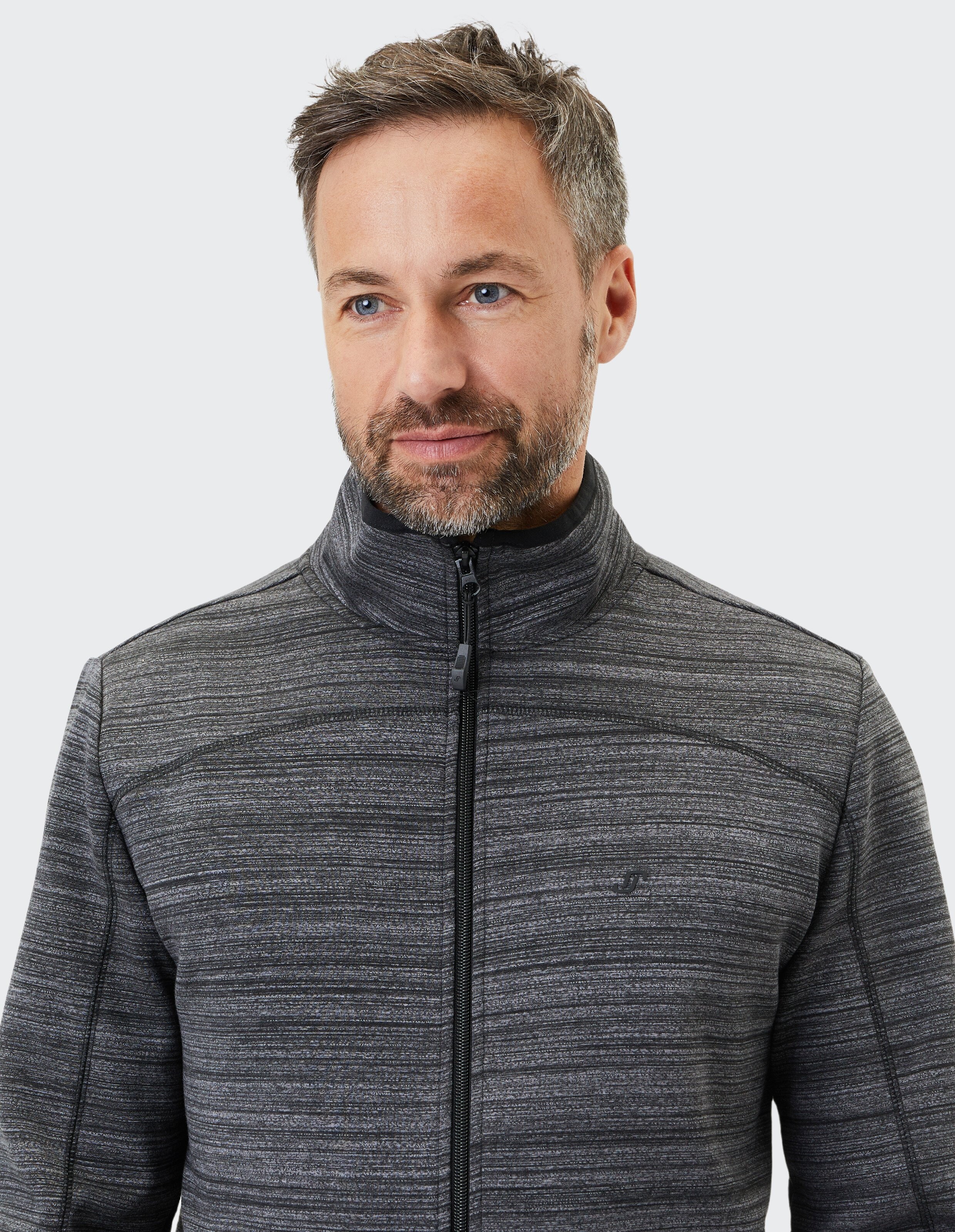 Nahaufnahme eines Mannes, der eine stilvolle graue Jacke mit Reißverschluss und Strukturmuster trägt.