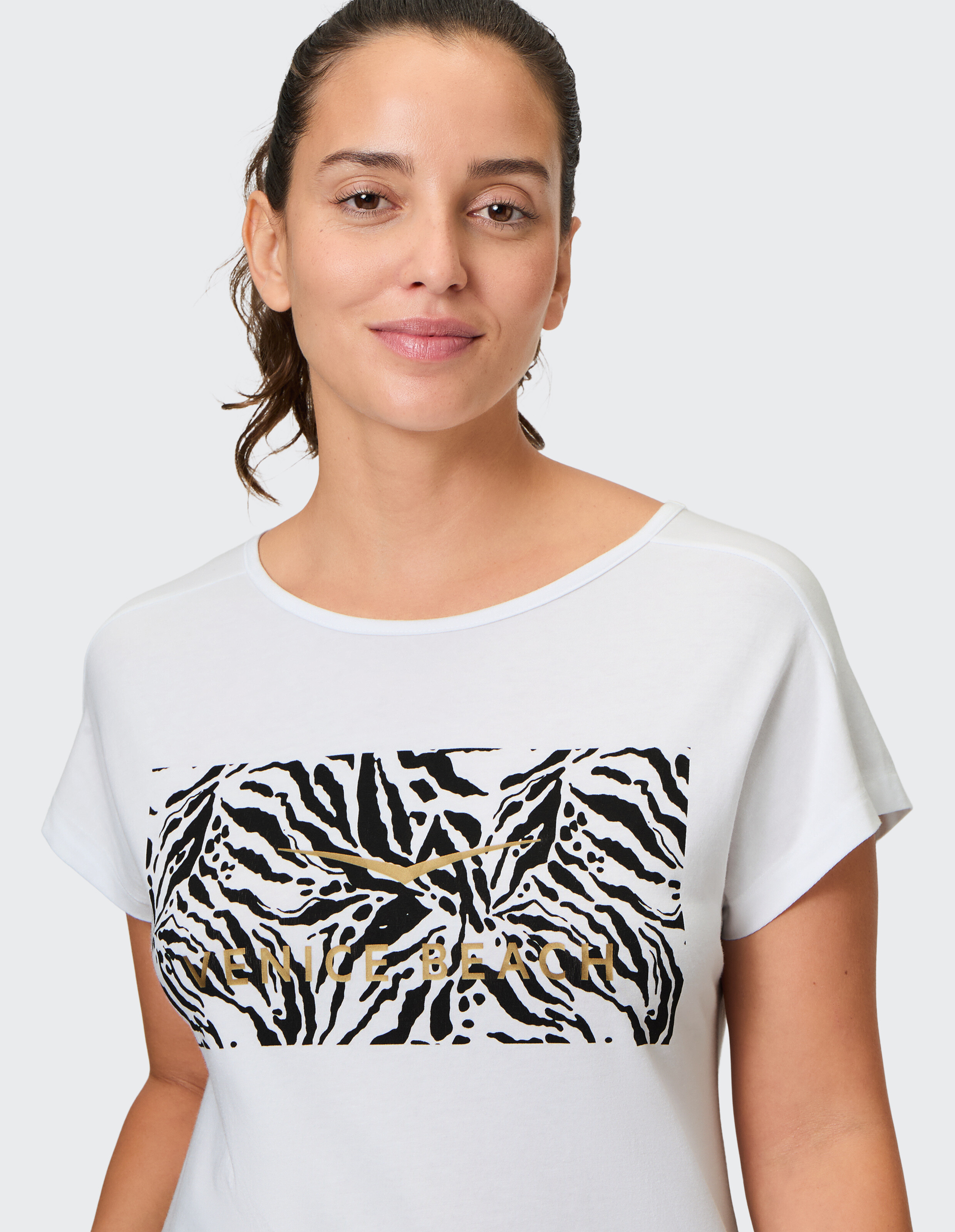 Weißes, lässiges T-Shirt mit schwarz-weißem Zebradruck und „Venice Beach“-Schriftzug.