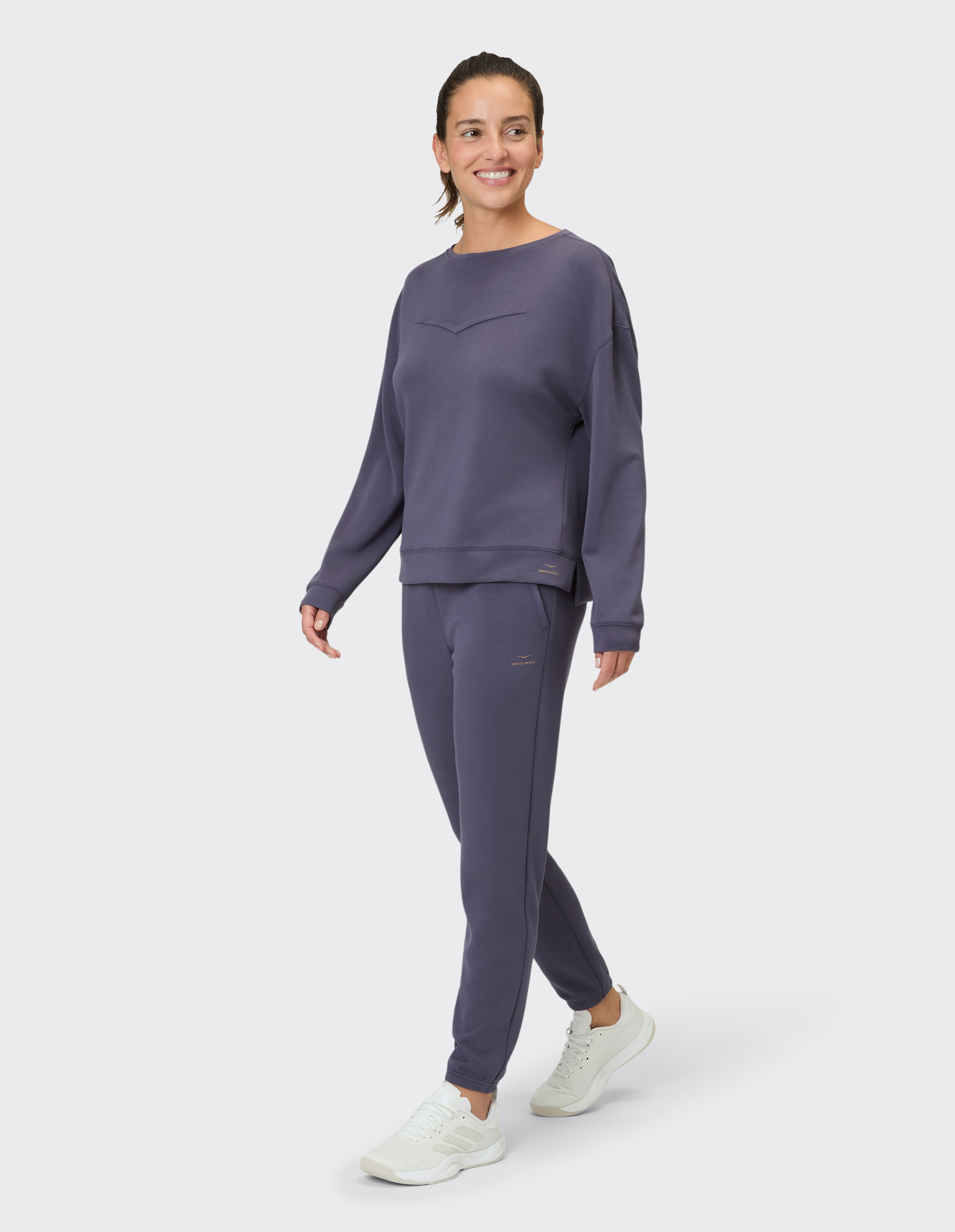 Frau in einem gemütlichen lila Sweatshirt und passenden Jogginghosen, perfekt für Freizeitkleidung.