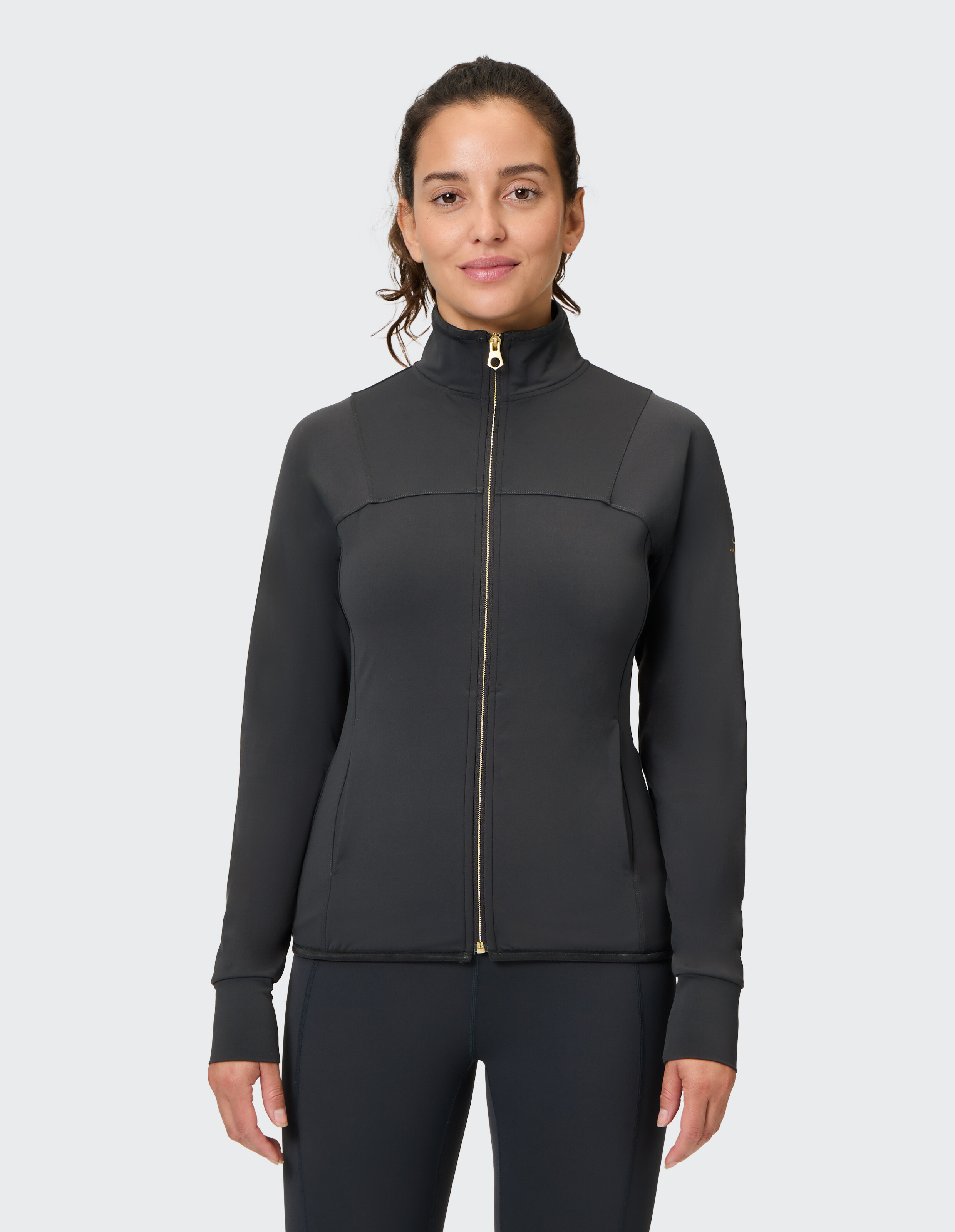 Schwarze Damenjacke mit Reißverschluss, hohem Kragen und goldenem Reißverschlussdetail.