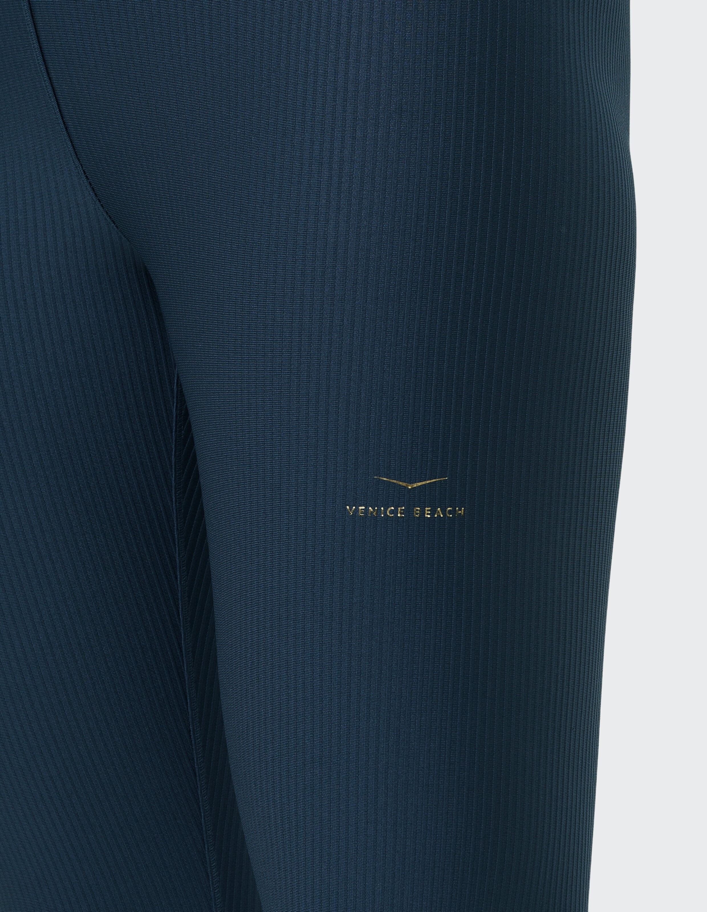 Nahaufnahme einer marineblauen gerippten Strumpfhose von Venice Beach Ravenna mit goldenem Logo.