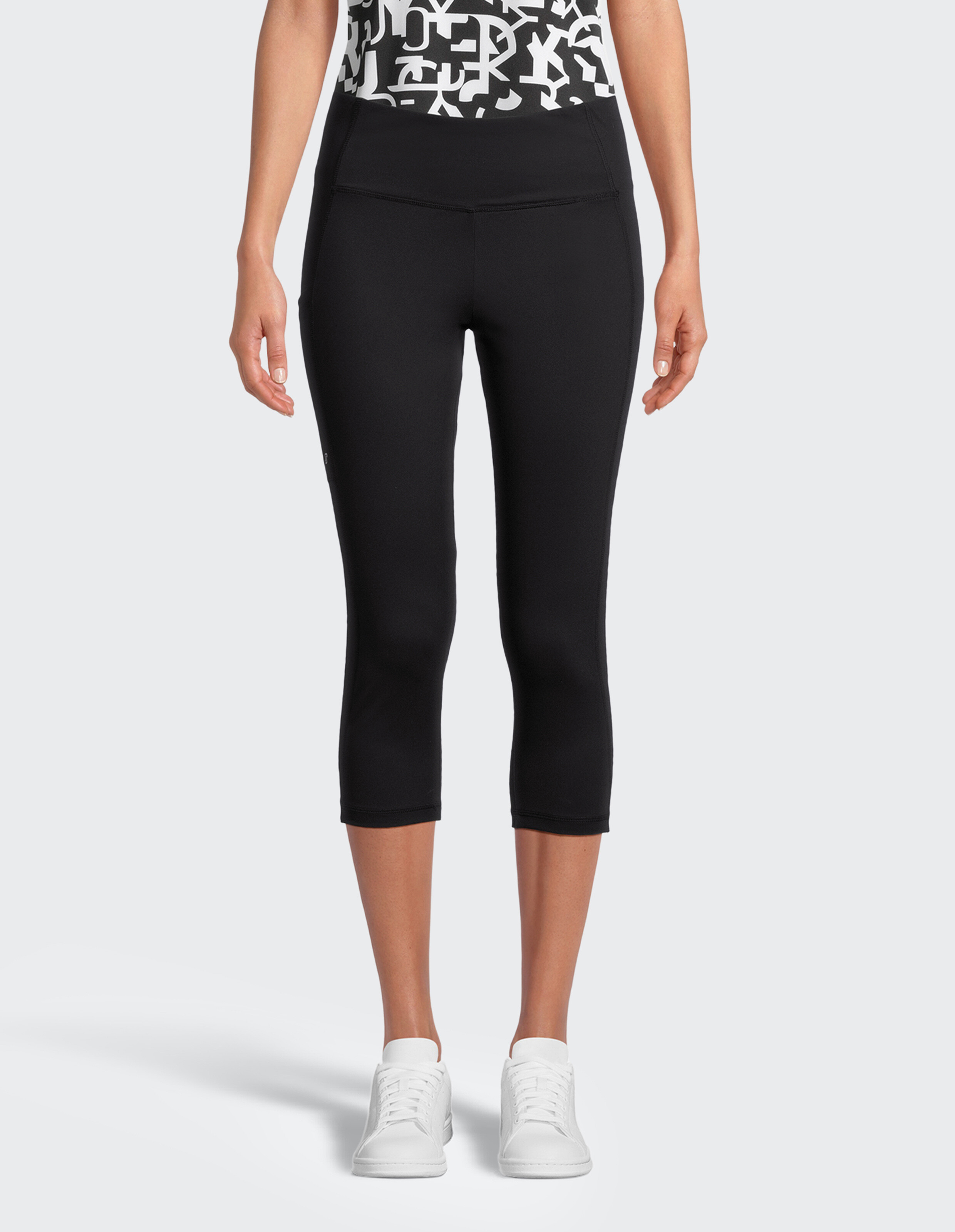 Dreiviertellange, schwarze Leggings mit hohem Bund, aus glattem, elastischem Material, ohne sichtbare Logos oder Muster.