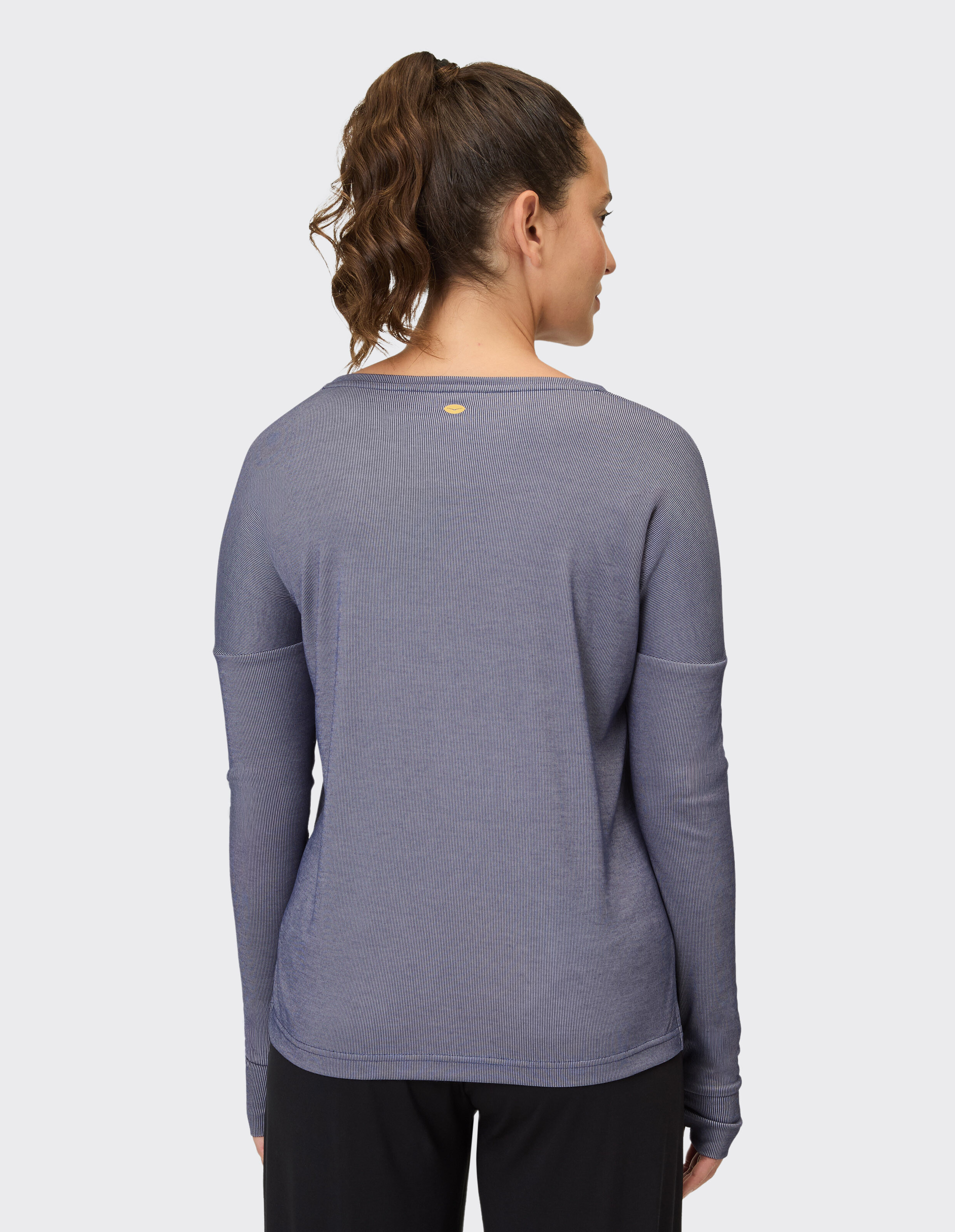Rückansicht einer Frau in einem kuscheligen blauen Langarmshirt, perfekt für Freizeitkleidung.