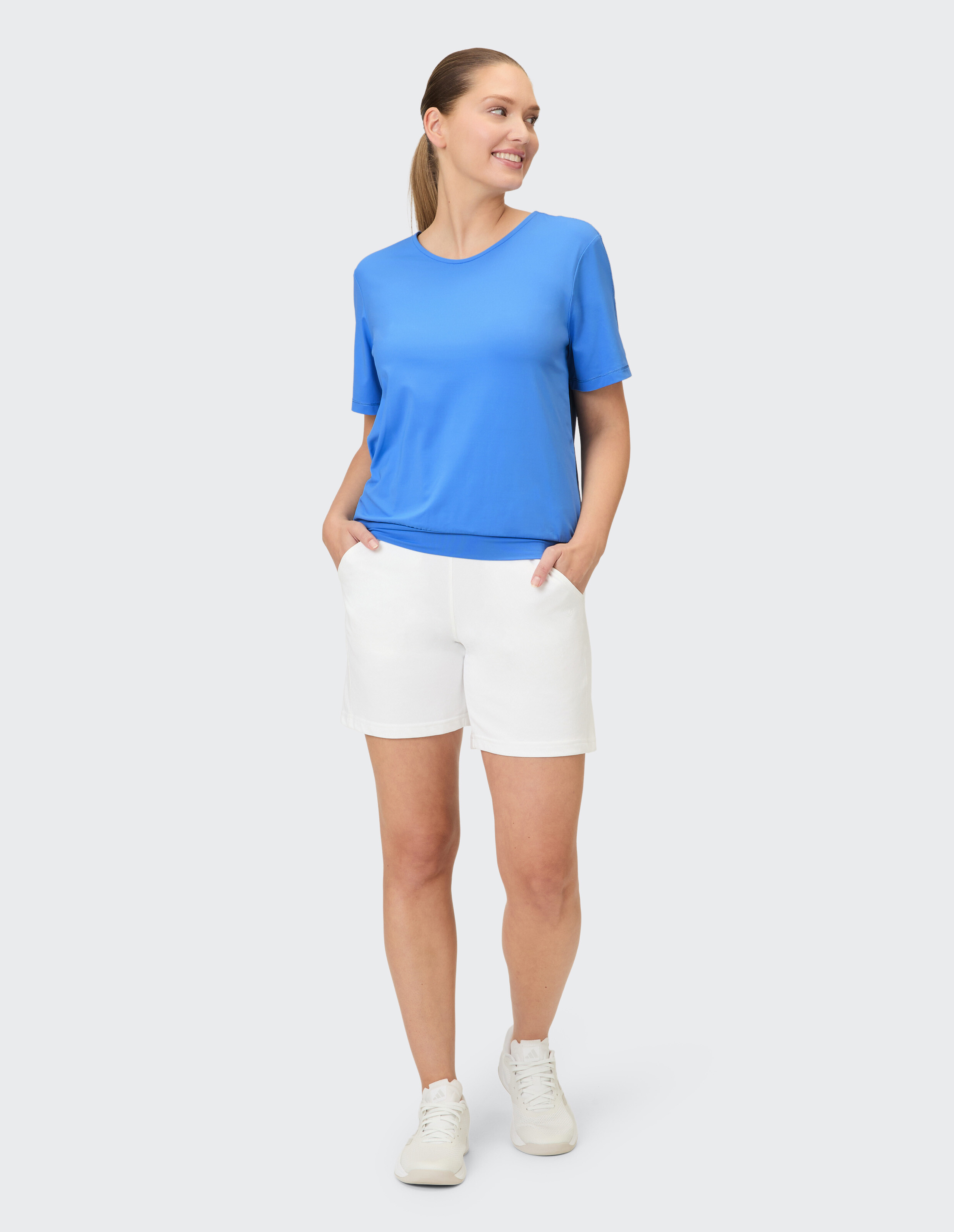 Frau in einem blauen T-Shirt und weißen Shorts, perfekt für lässige Sommerausflüge.