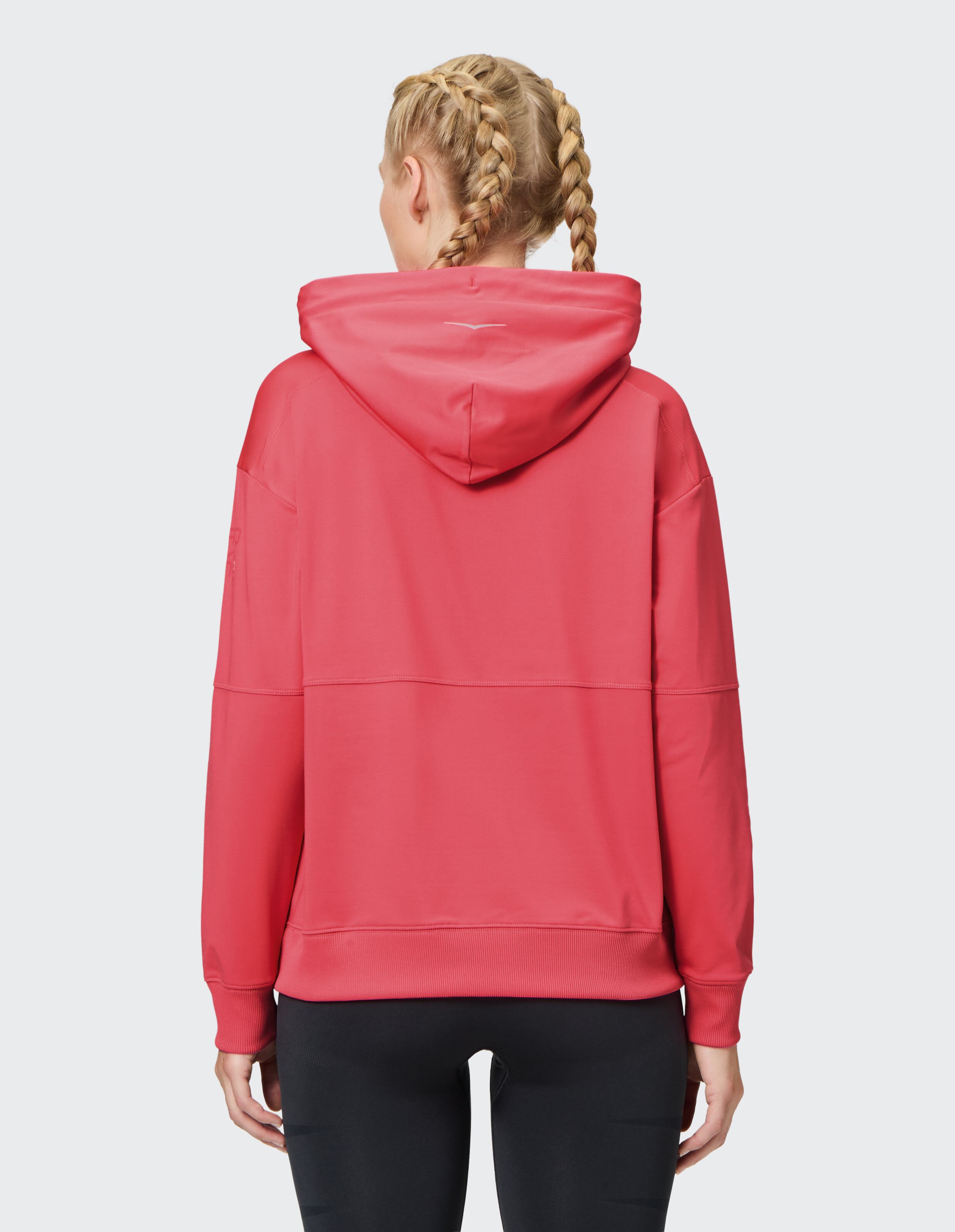 Rückansicht einer Frau in einem rosa Kapuzenpullover, perfekt für Freizeitkleidung und Faulenzen.