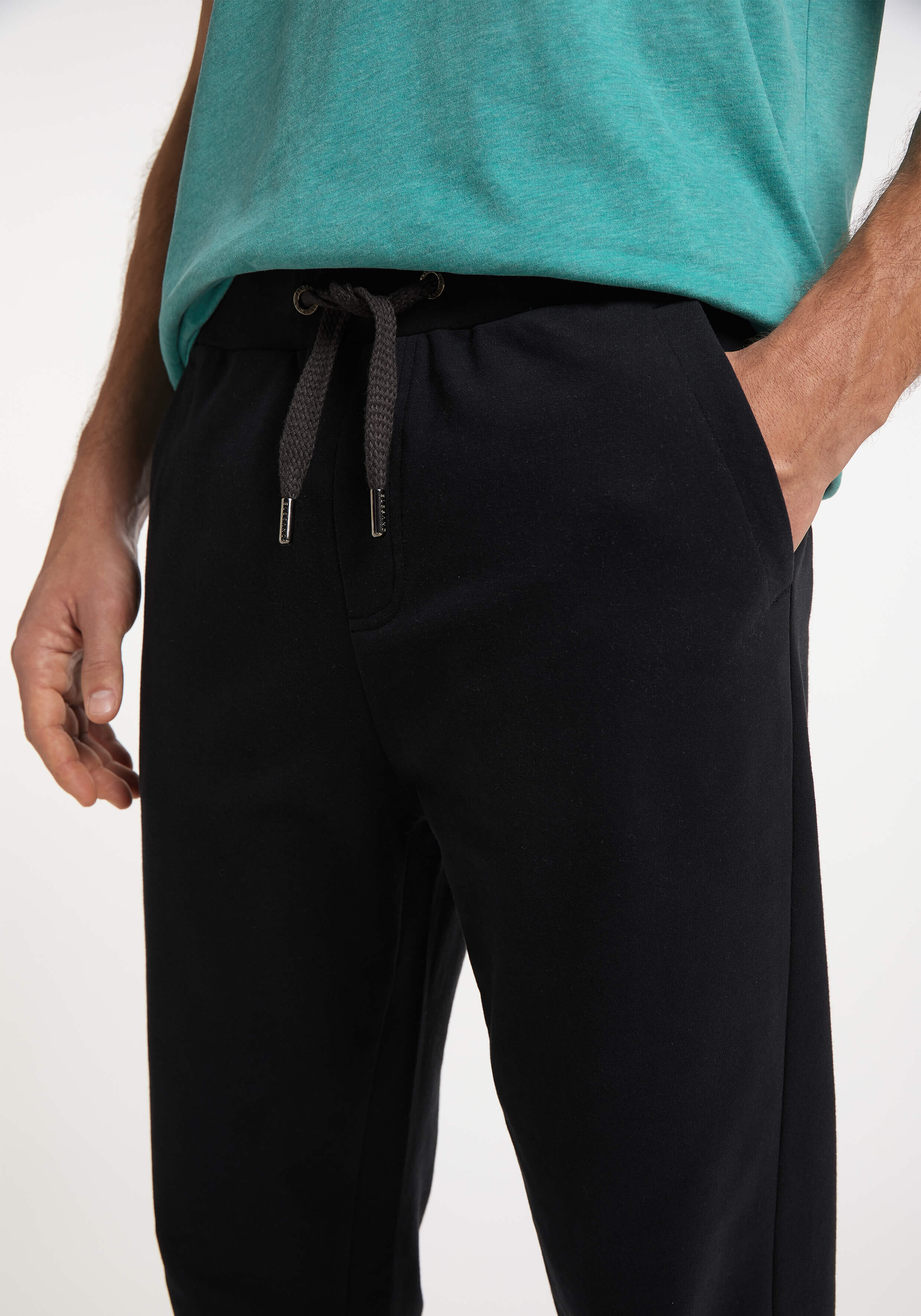 Mann trägt bequeme schwarze Freizeit-Jogginghose mit Kordelzug in der Taille.