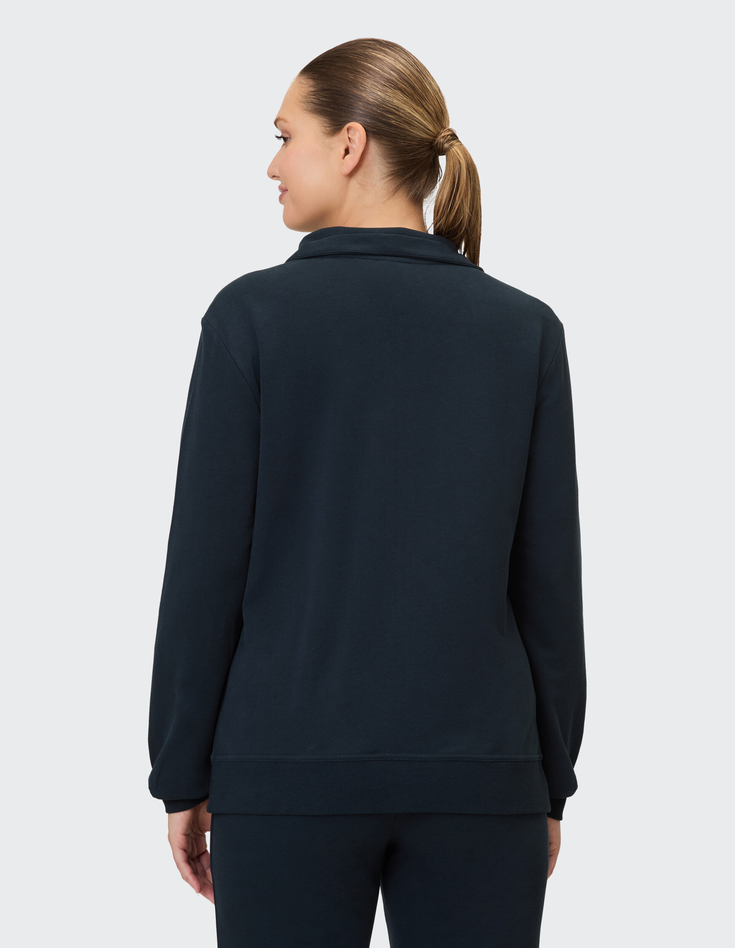 Rückansicht einer Frau in einem kuscheligen marineblauen Sweatshirt, perfekt für Freizeitkleidung.