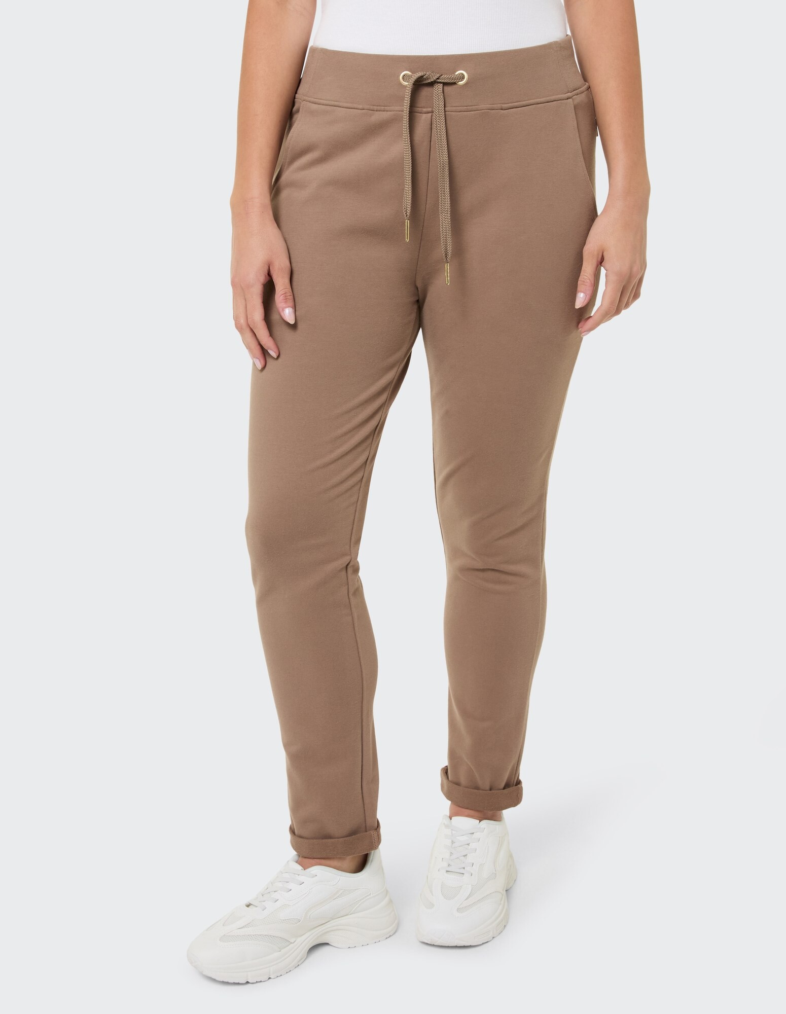 Lässige braune Jogginghose mit Kordelzug, gepaart mit weißen Sneakers.