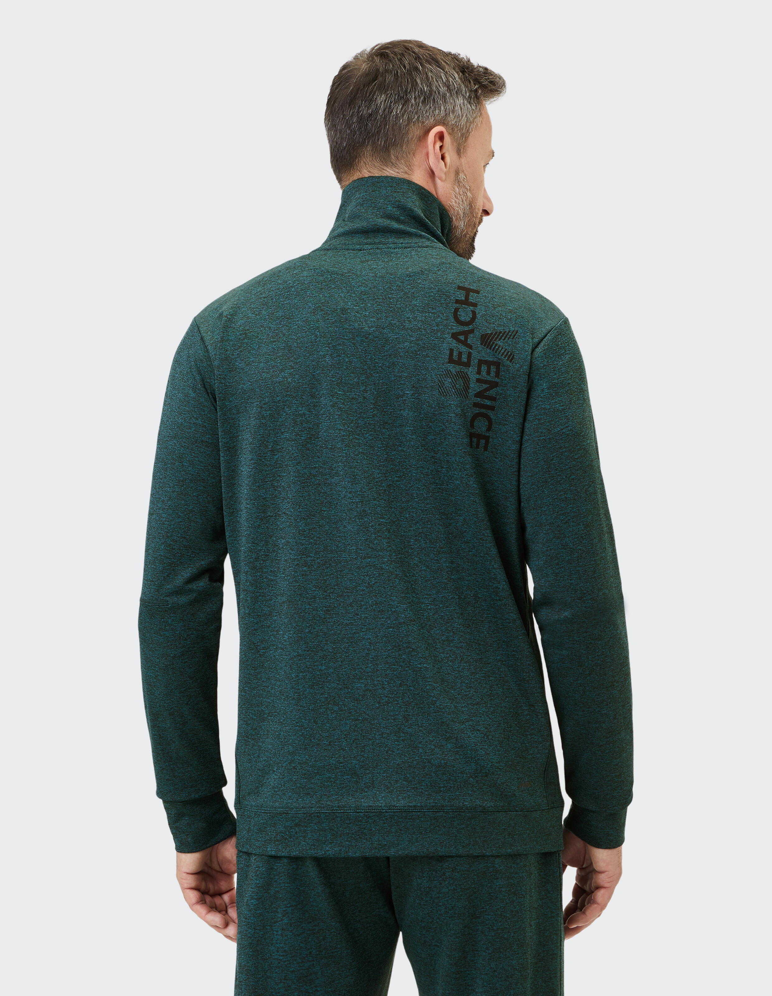 Mann trägt eine grüne Venice Beach Funktionsjacke von Clark, Rückansicht, lässiger Stil.