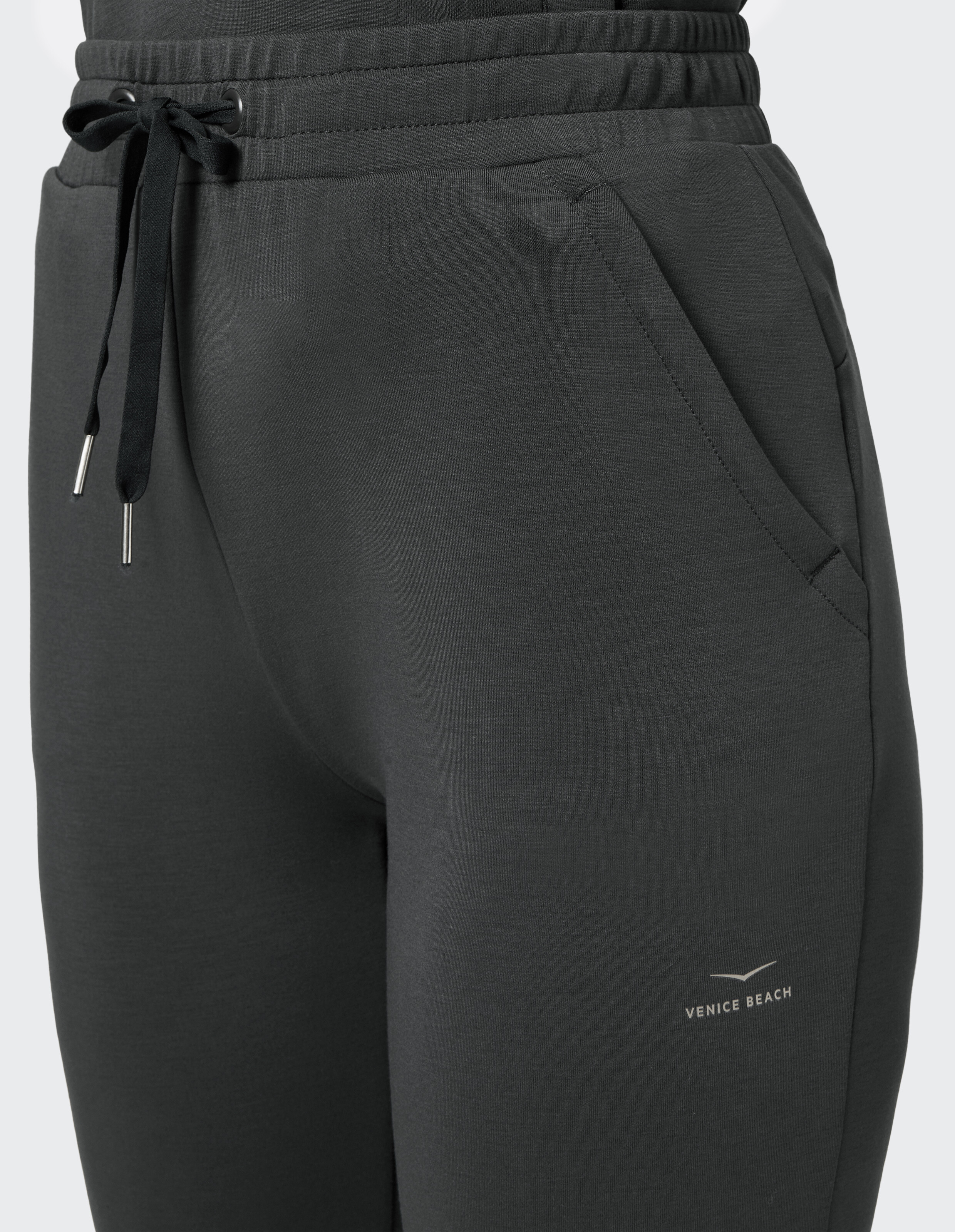 Nahaufnahme einer dunkelgrauen Jogginghose mit elastischem Bund und Seitentaschen.