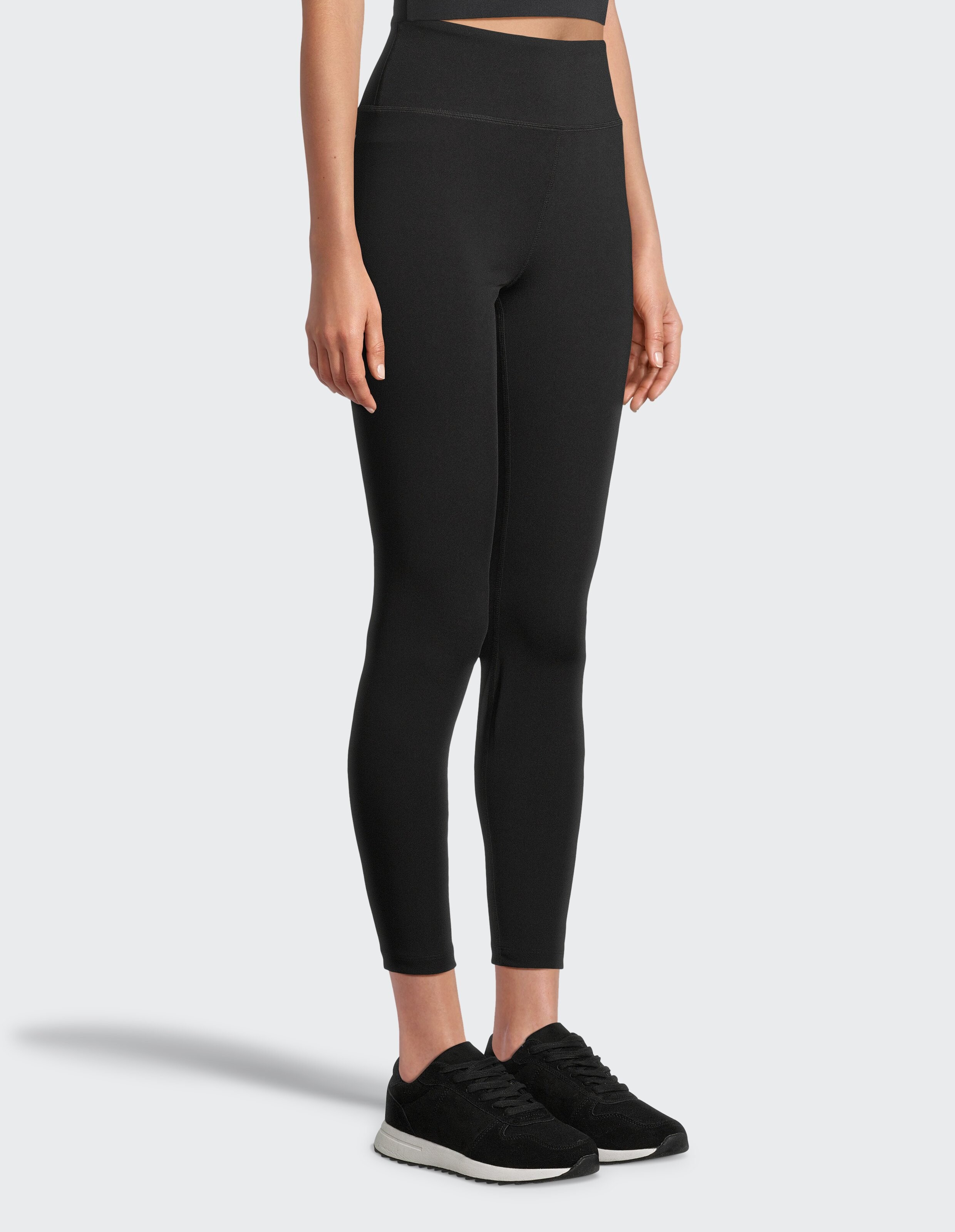 Frau trägt schwarze Leggings mit hohem Bund, perfekt für lässige Loungewear.