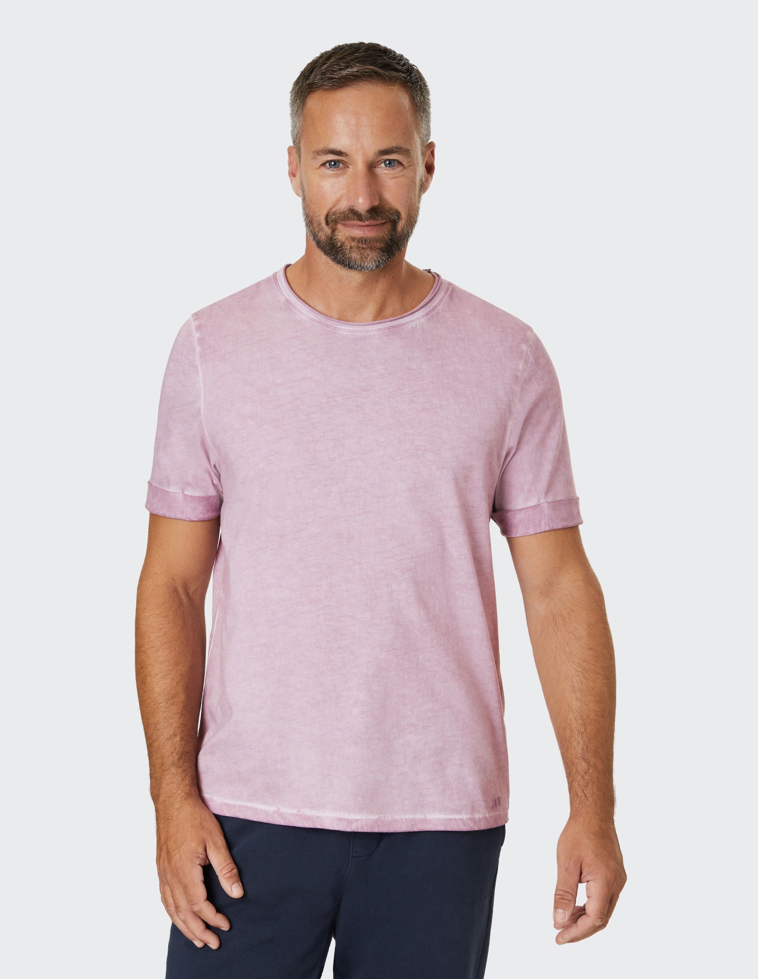 Ein pastellrosa T-Shirt mit Rundhalsausschnitt und umgeschlagenen Ärmeln, aus leicht meliertem Stoff, sorgt für einen lässigen Look.