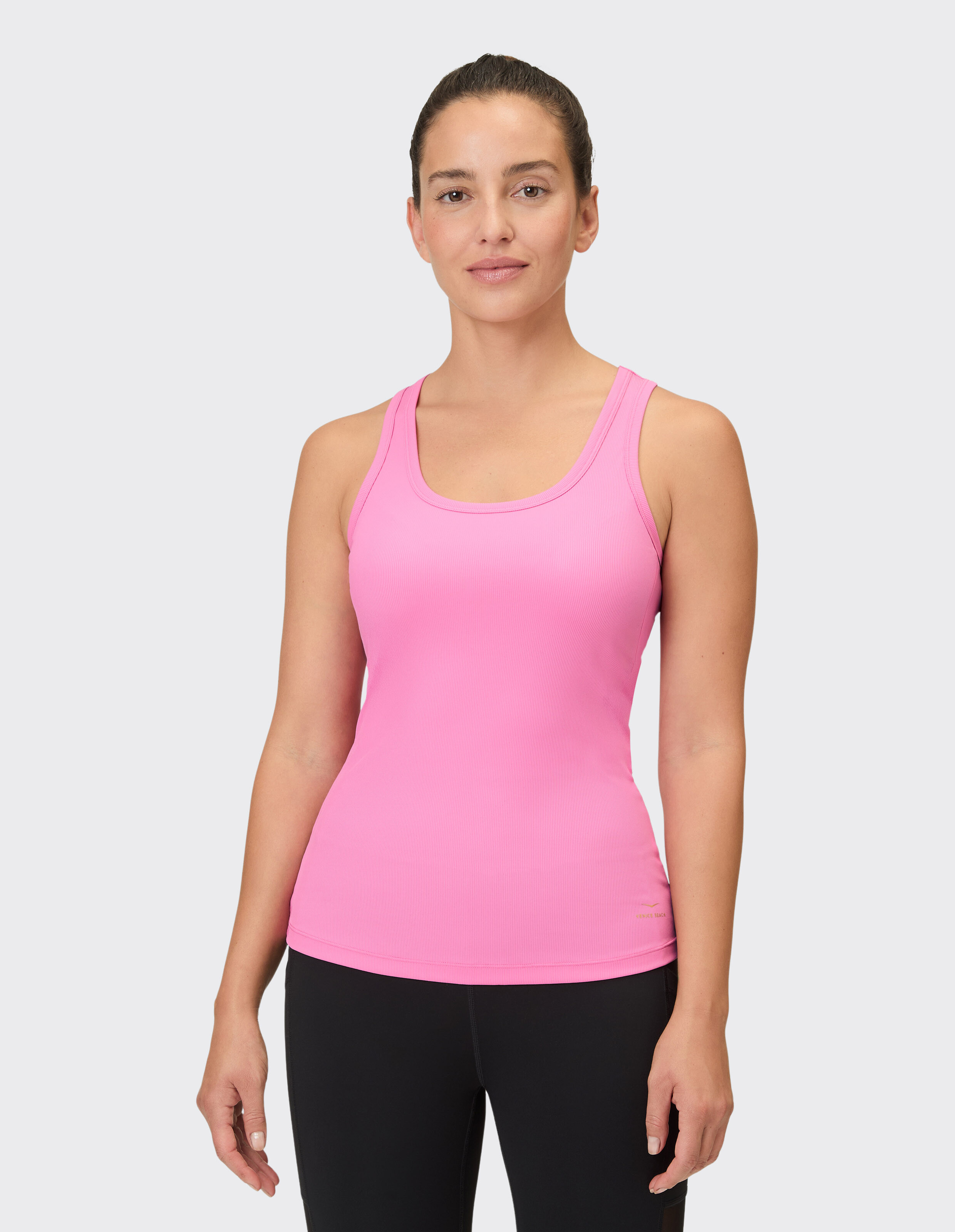 Frau trägt ein rosafarbenes Venice Beach Brenda-Tanktop für lässigen, bequemen Stil.