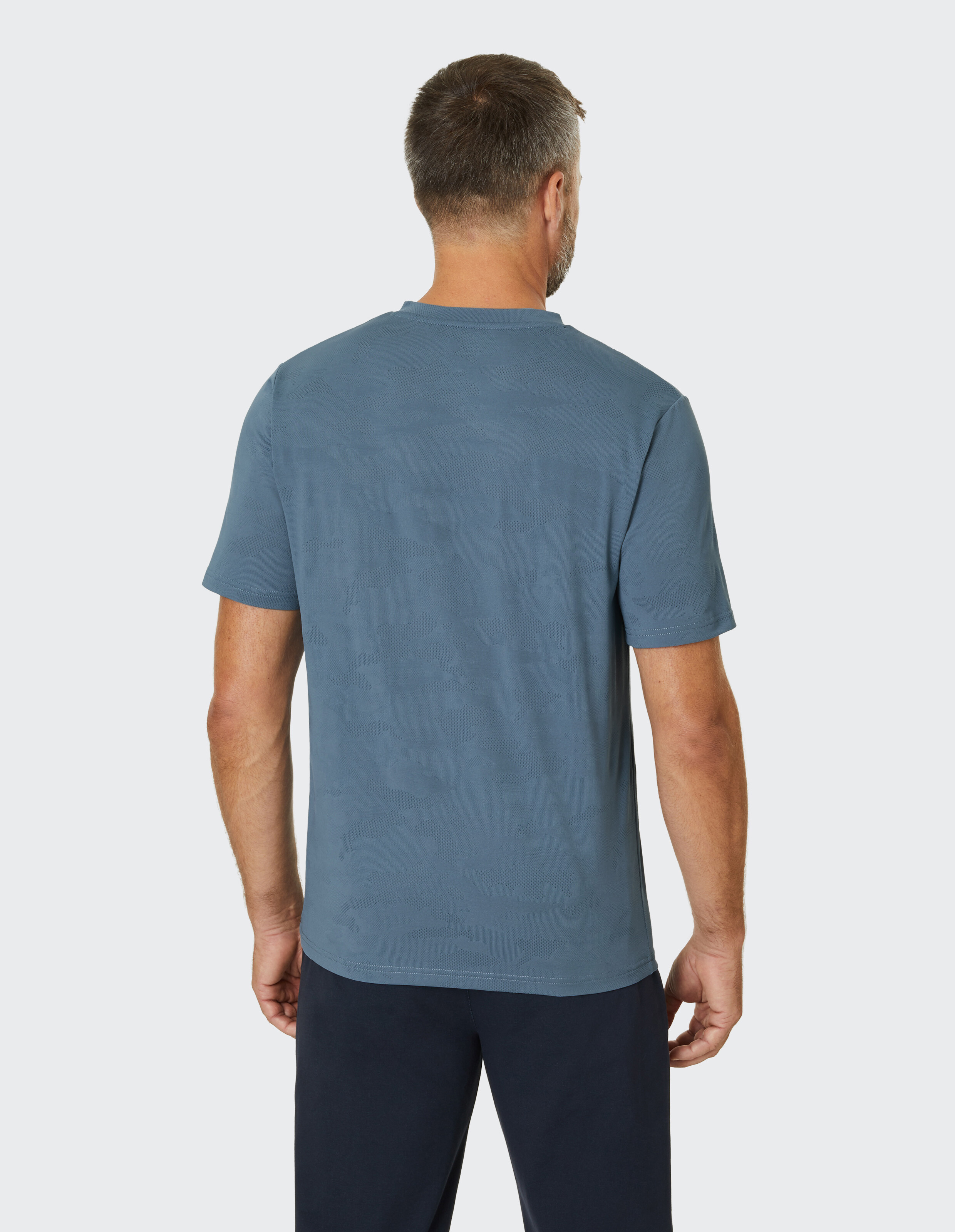 Blaues T-Shirt mit V-Ausschnitt und kurzen Ärmeln, dezentem Muster und kleinem Logo auf der Brust.