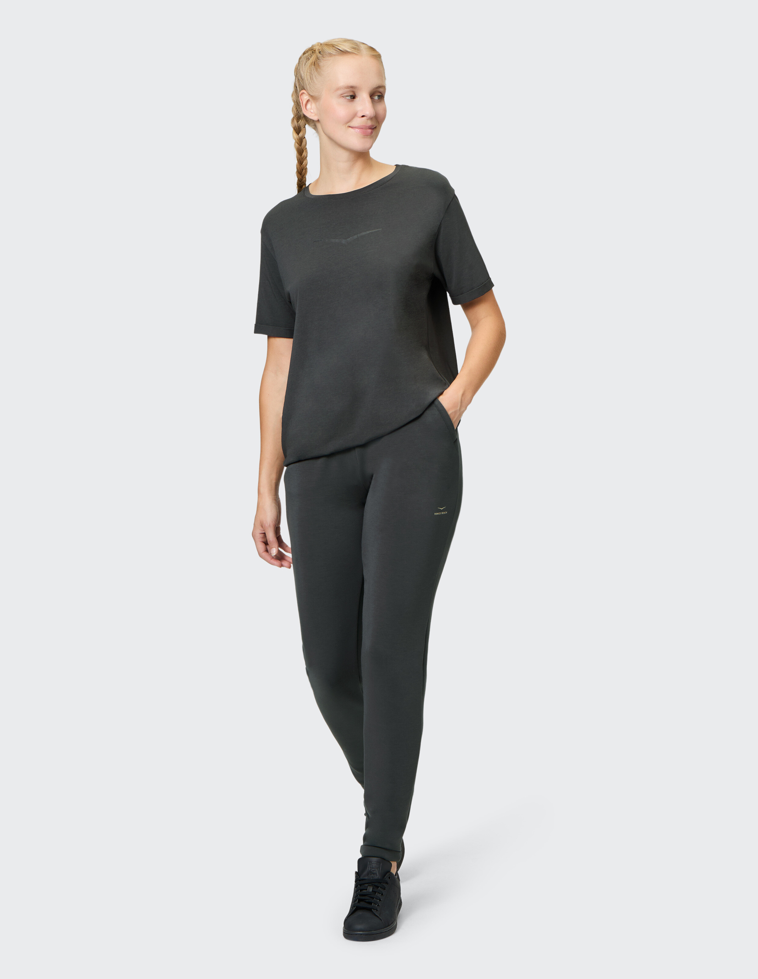Frau trägt ein dunkelgraues Venice Beach Kurzarmshirt Freya und eine passende Freizeithose.