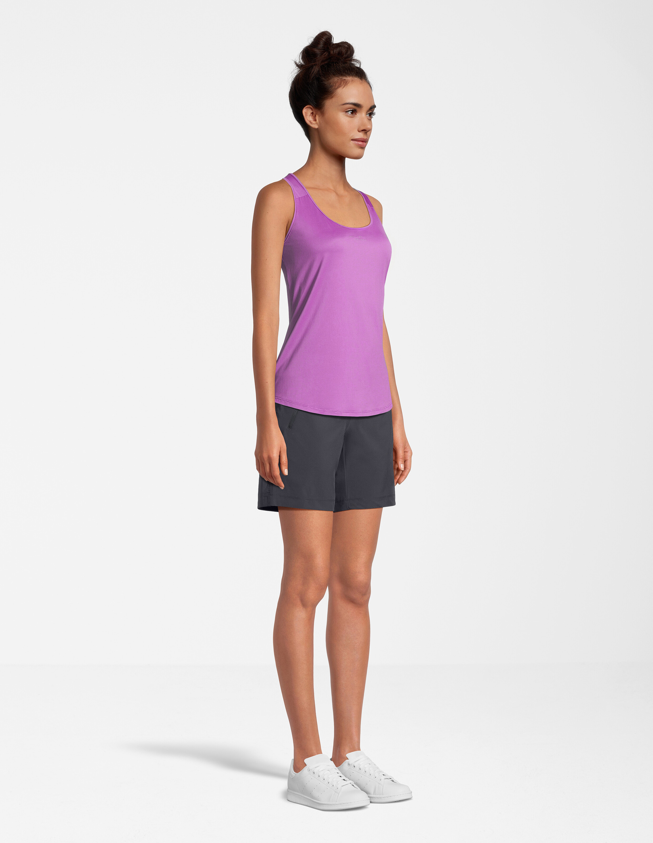 Frau trägt ein lila Tanktop und dunkelgraue Shorts für einen lässigen, bequemen Look.