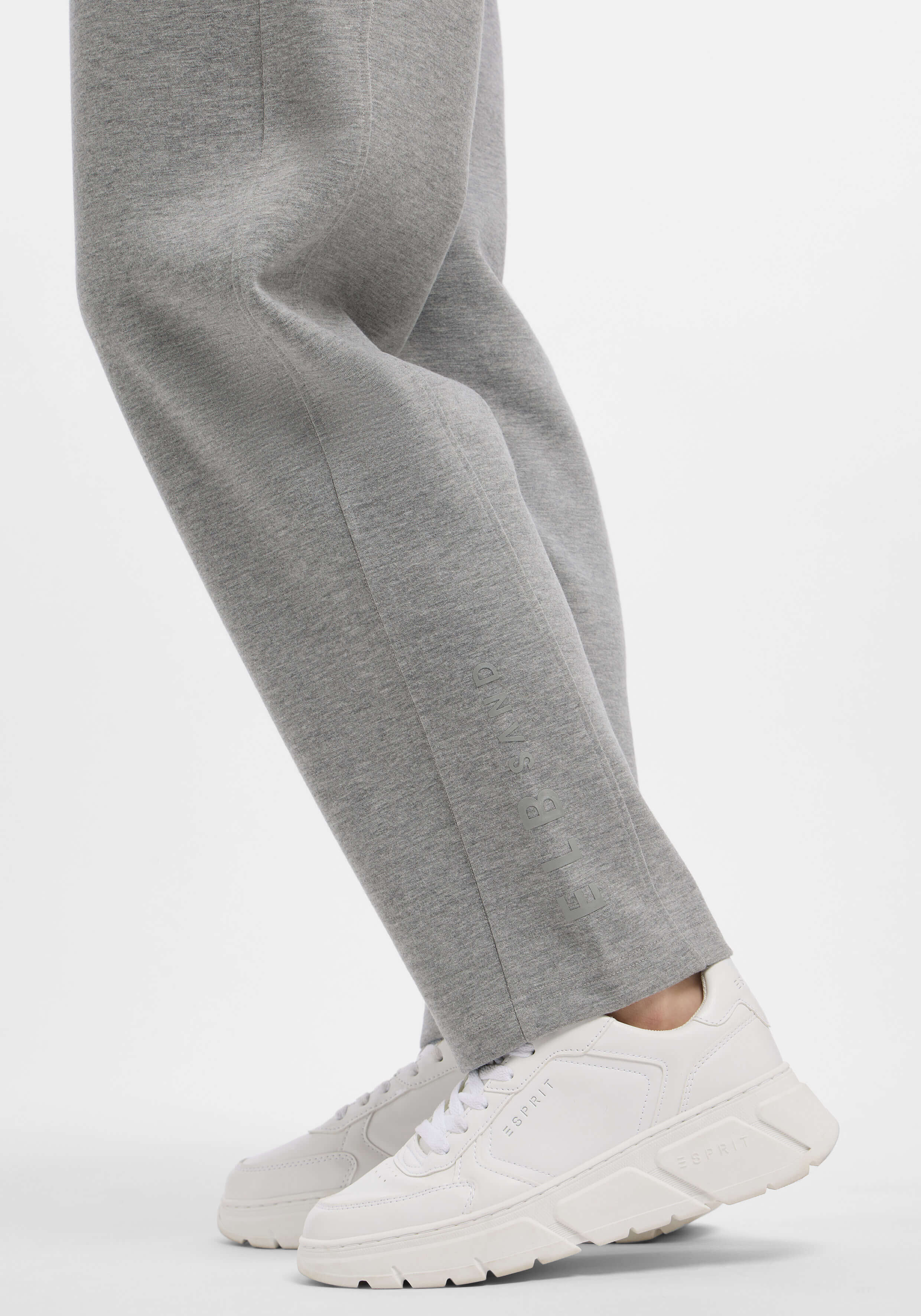 Lässige graue Jogginghose gepaart mit weißen Sneakers, ideal für entspannte Ausflüge.