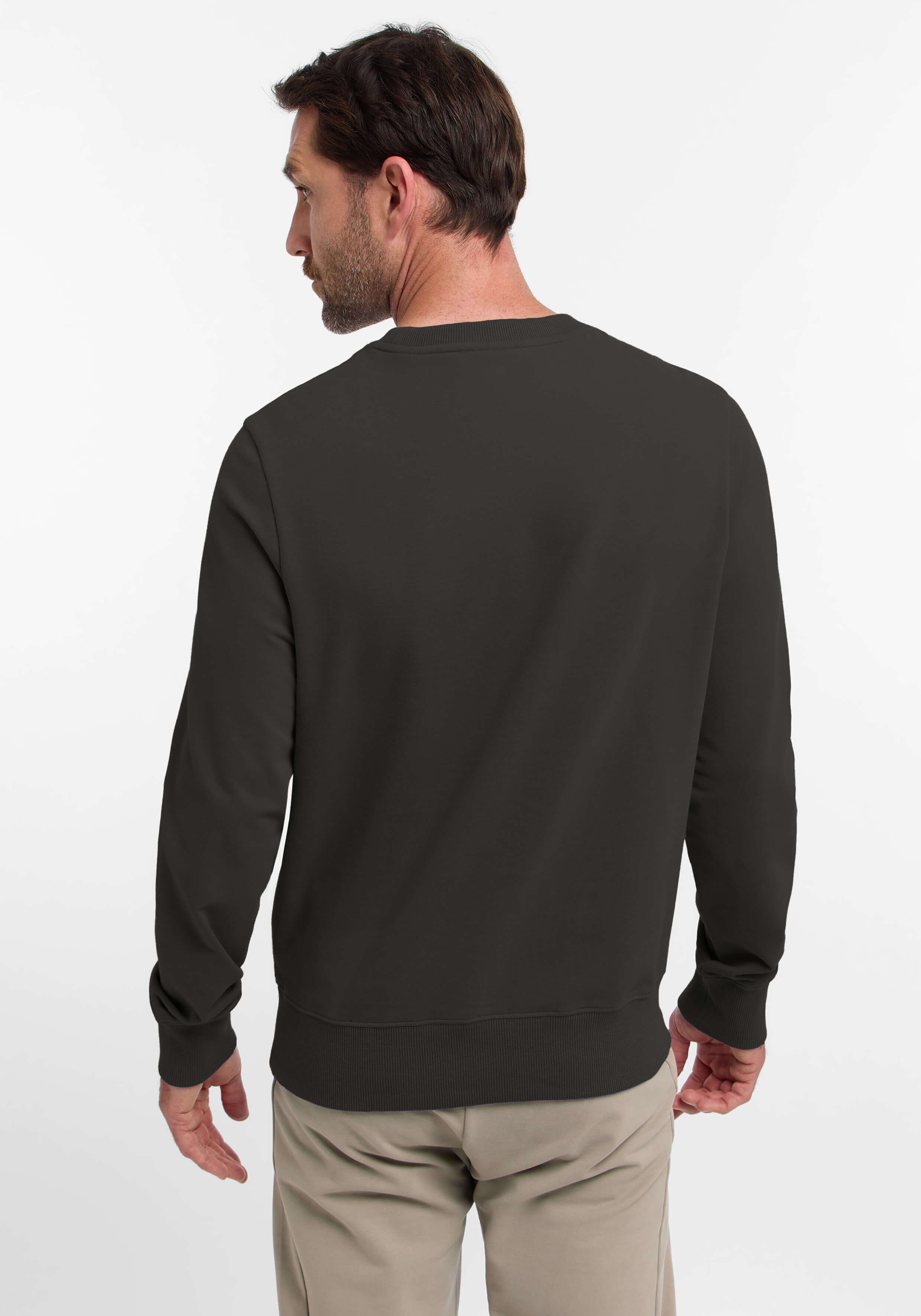 Mann trägt ein dunkelbraunes Sweatshirt und zeigt einen lässigen und bequemen Stil.