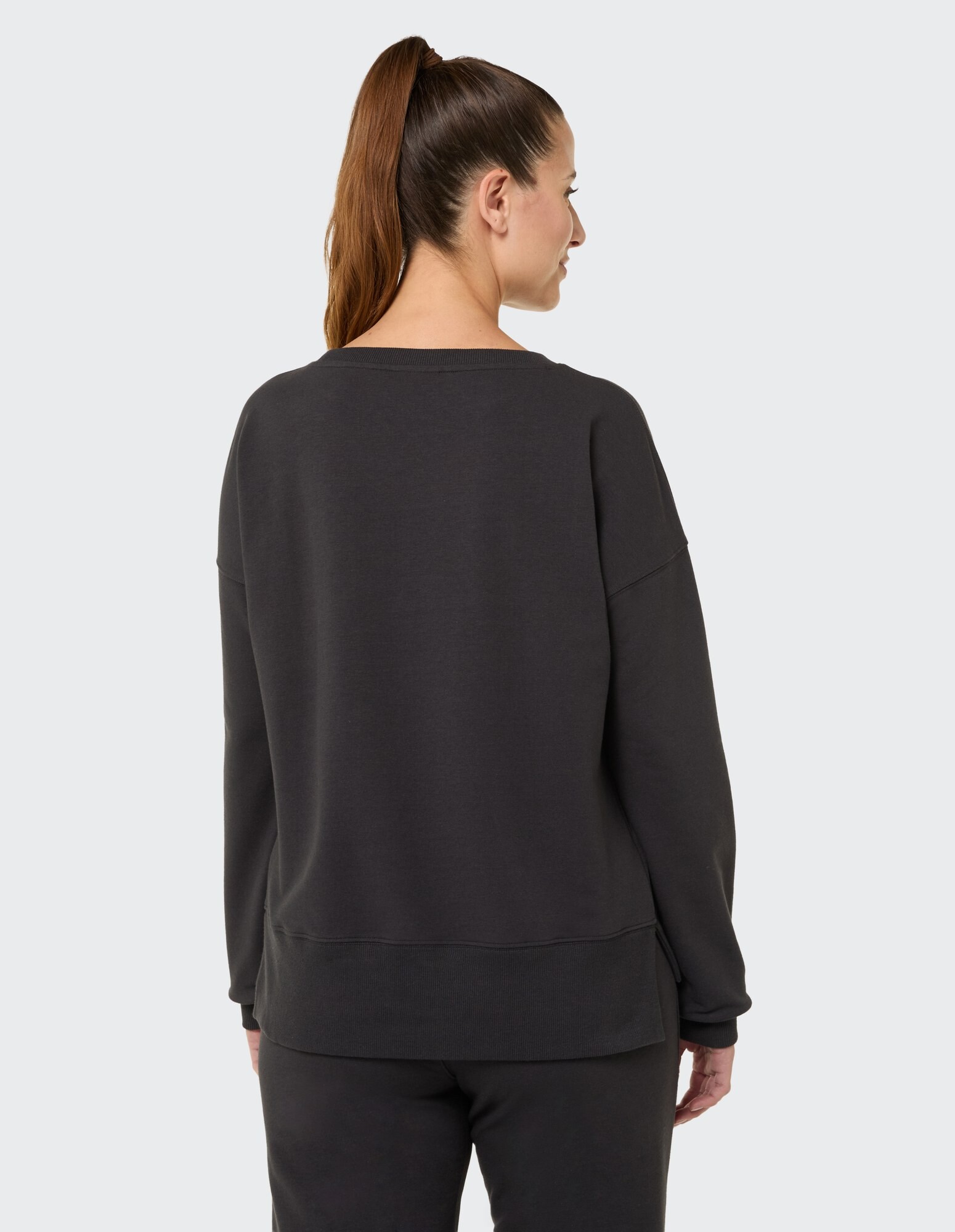 Rückansicht einer Frau in einem dunkelgrauen, übergroßen Sweatshirt, perfekt für Freizeitkleidung.