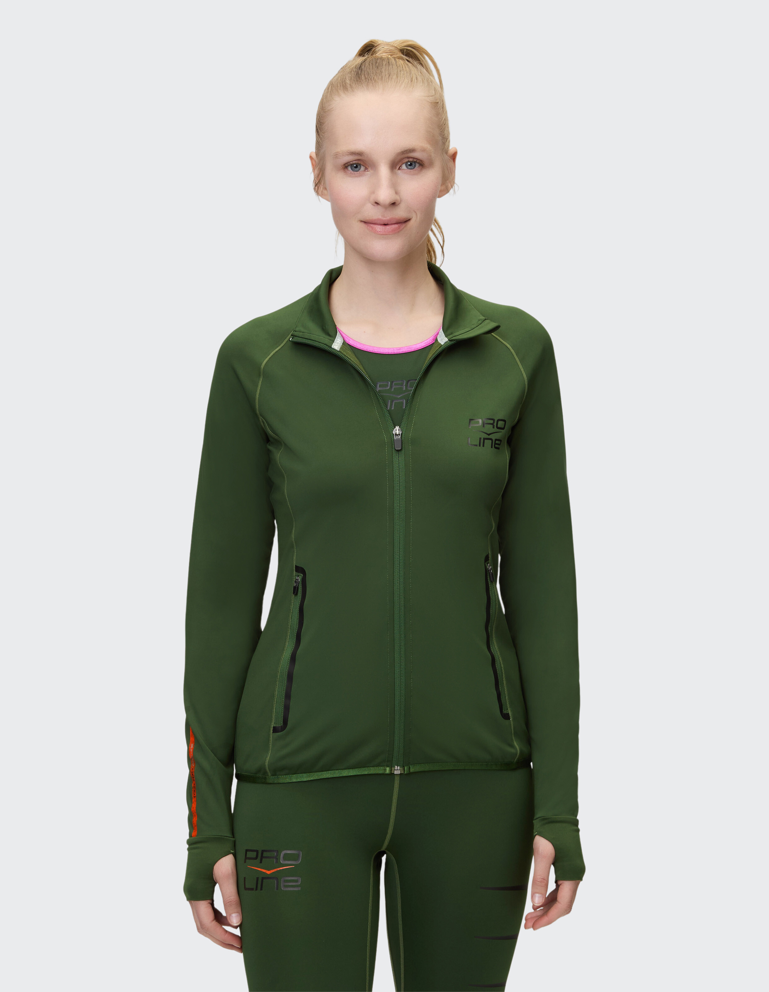 Frau trägt eine grüne Sportjacke mit Reißverschluss für lässige Outdoor-Aktivitäten.