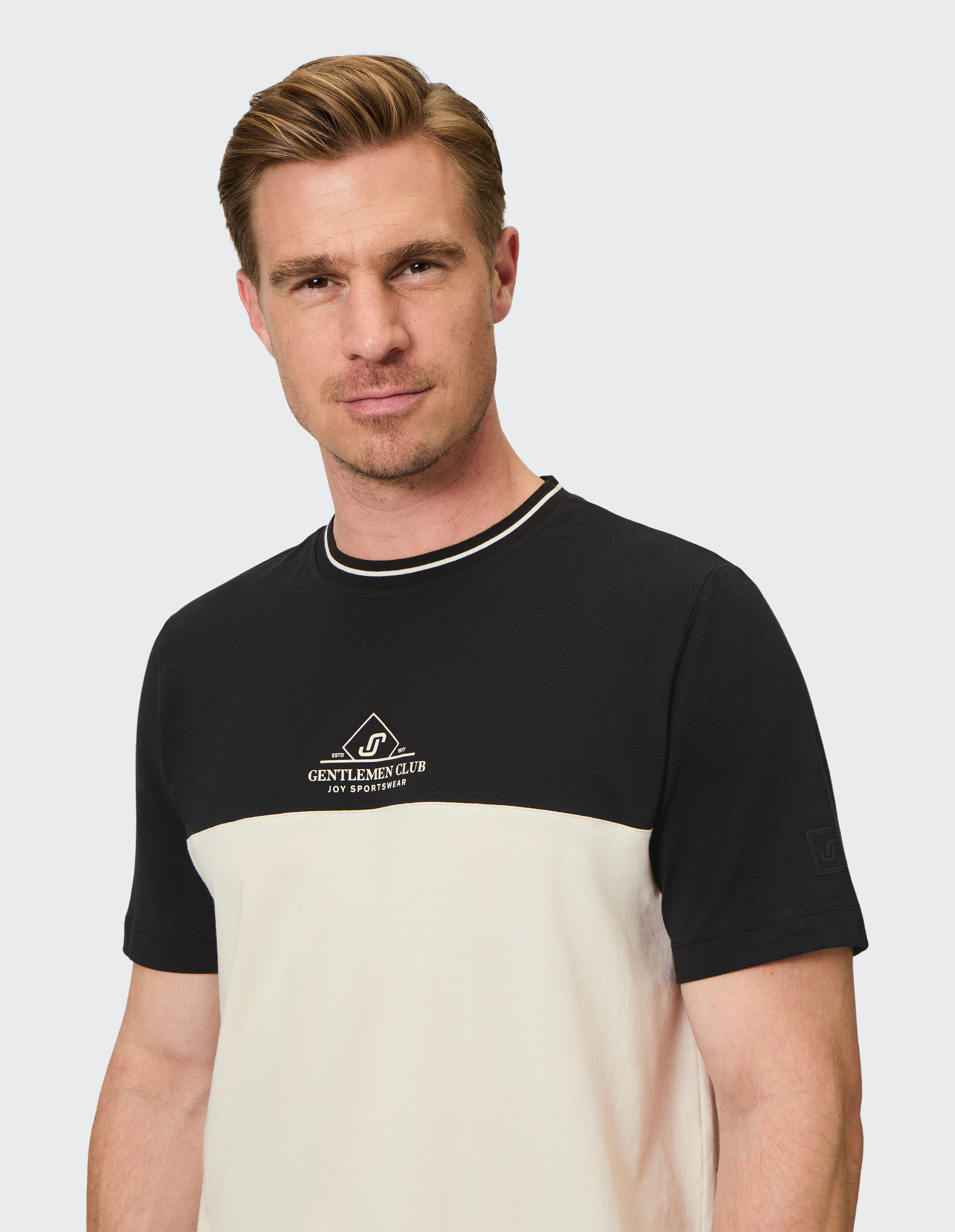 Lässiges Herren-T-Shirt im schwarz-cremefarbenen Farbblockdesign mit Logo, perfekt für entspannte Ausflüge.
