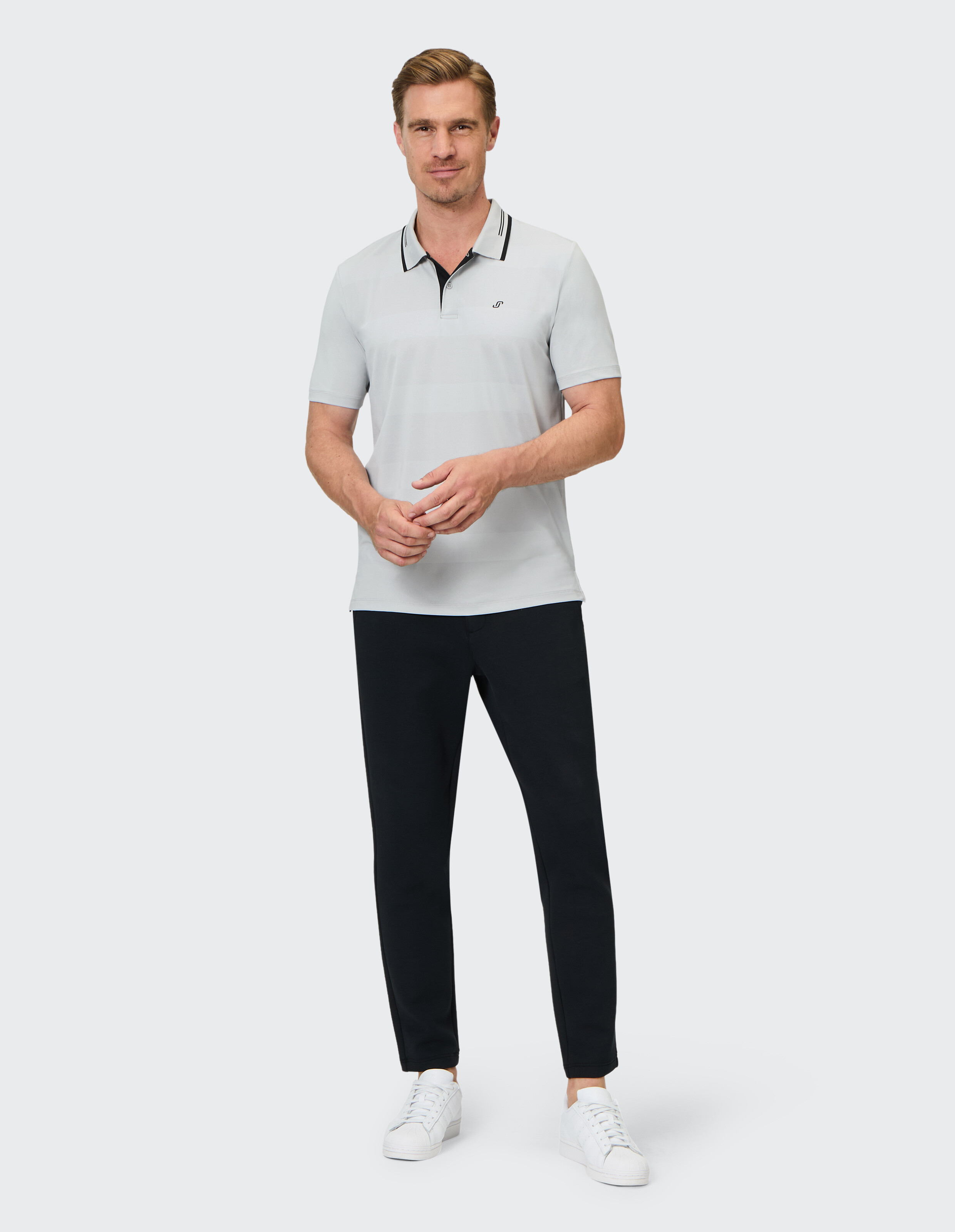 Mann trägt ein hellgraues Poloshirt und eine dunkle Hose für einen klassischen Casual-Look.