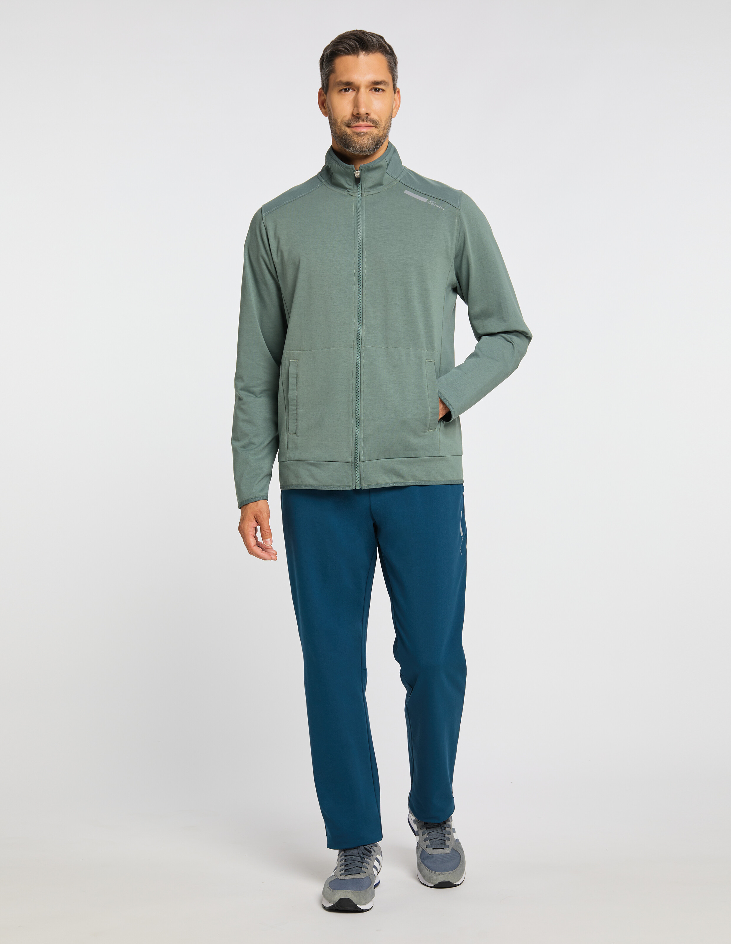 Grüne Jacke mit Reißverschluss und Stehkragen, minimalistisches Design, mit Taschen und dezentem Logo auf der Brust.