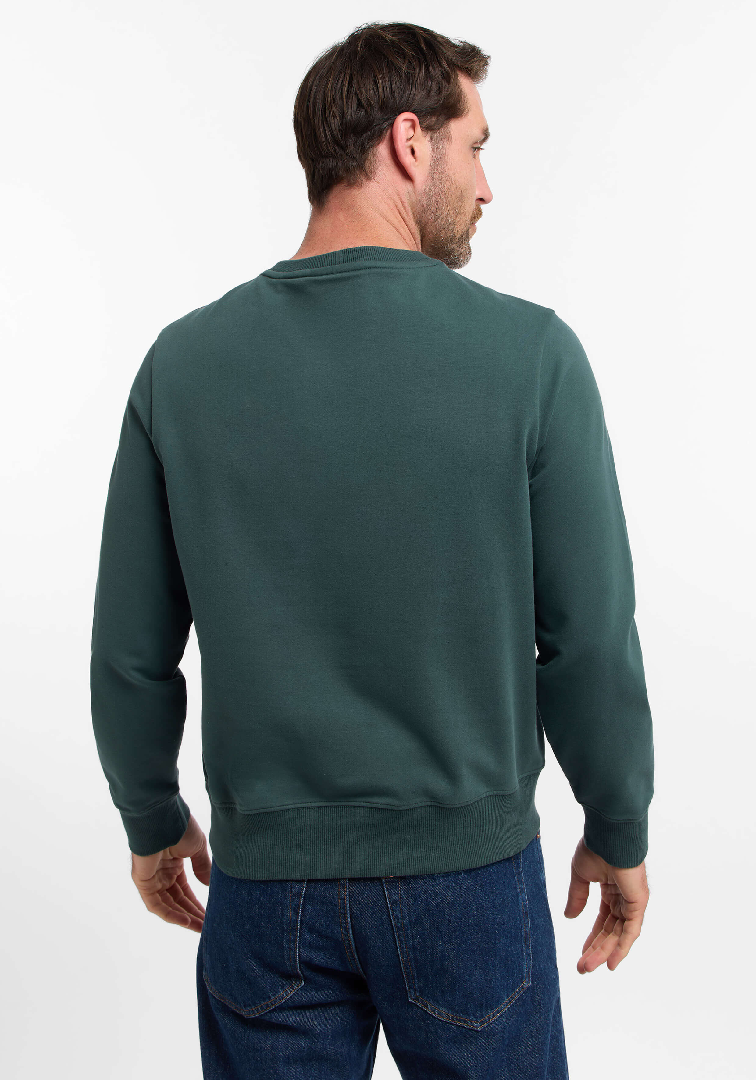 Rückansicht eines Mannes, der ein grünes Sweatshirt mit lässigen Jeans trägt.