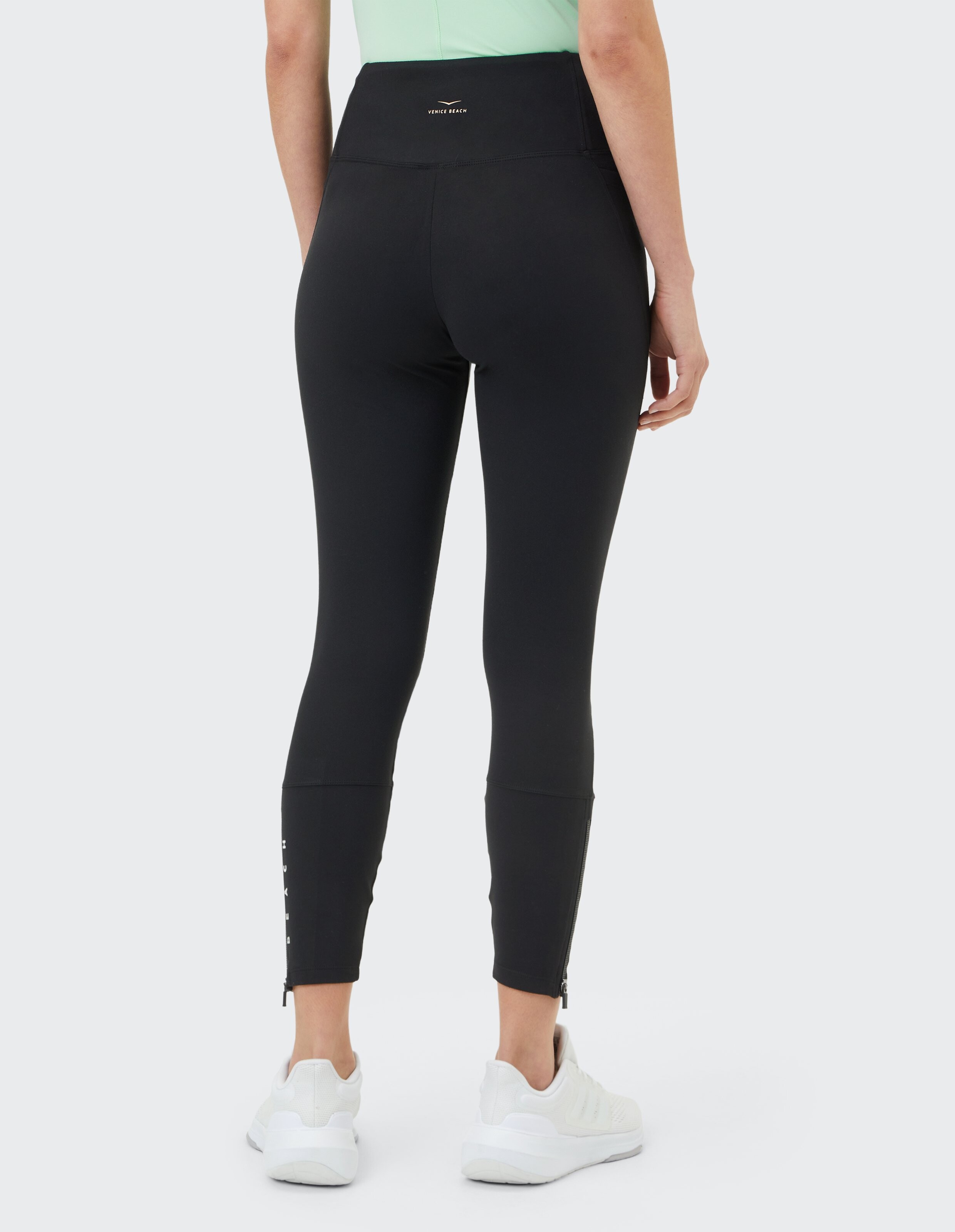 Rückansicht einer schwarzen Leggings mit hoher Taille und Reißverschlussdetails für Freizeitkleidung.