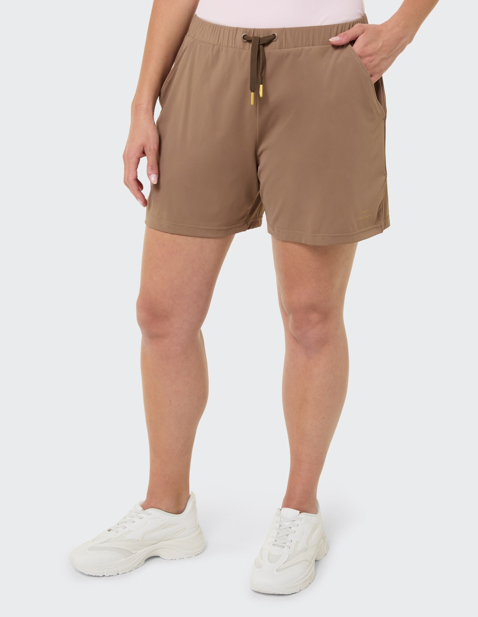 Lässige braune Shorts mit Taschen und Kordelzug, gepaart mit weißen Sneakers.