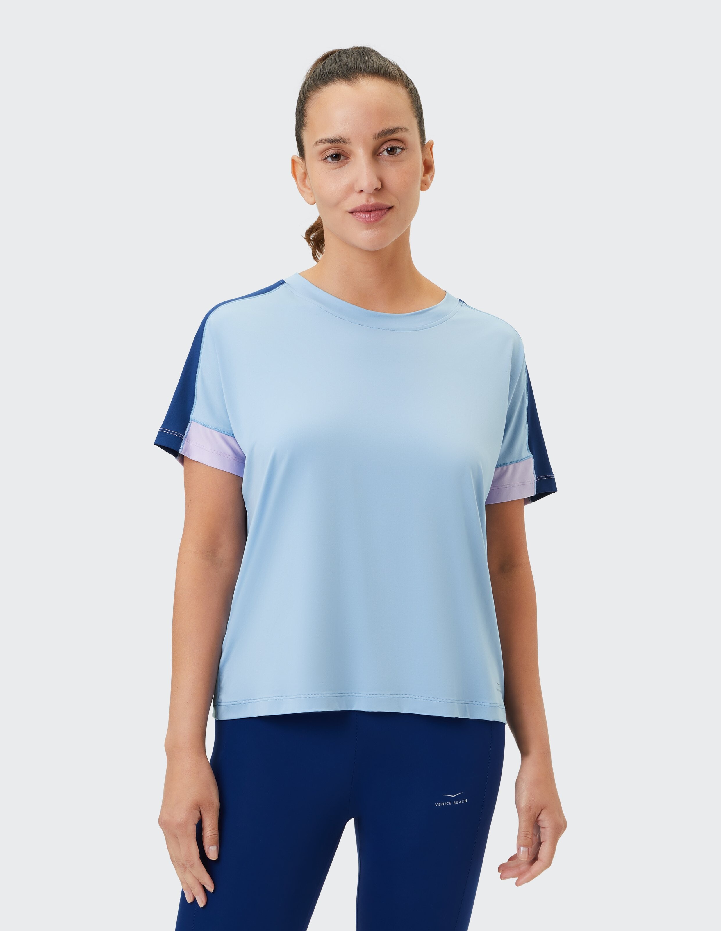 Hellblaues Freizeitoberteil mit marineblauen und violetten Akzenten, perfekt für aktive Kleidung.
