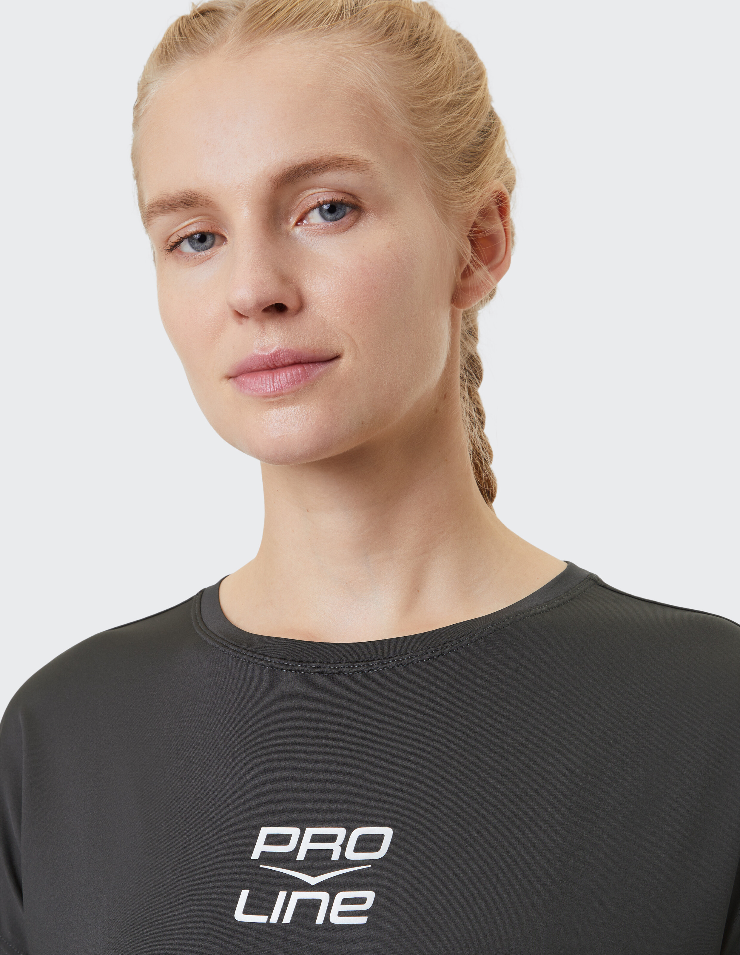 Nahaufnahme einer Frau in einem schwarzen PRO LINE-Freizeitoberteil, die einen entspannten Stil unterstreicht.
