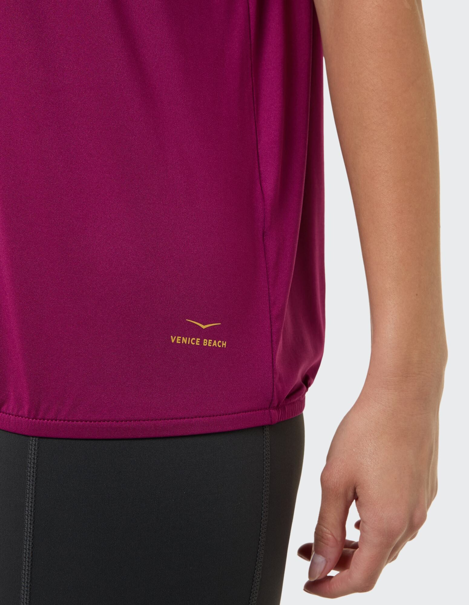 Nahaufnahme eines kastanienbraunen Damen-Sportoberteils mit Venice Beach-Logo.