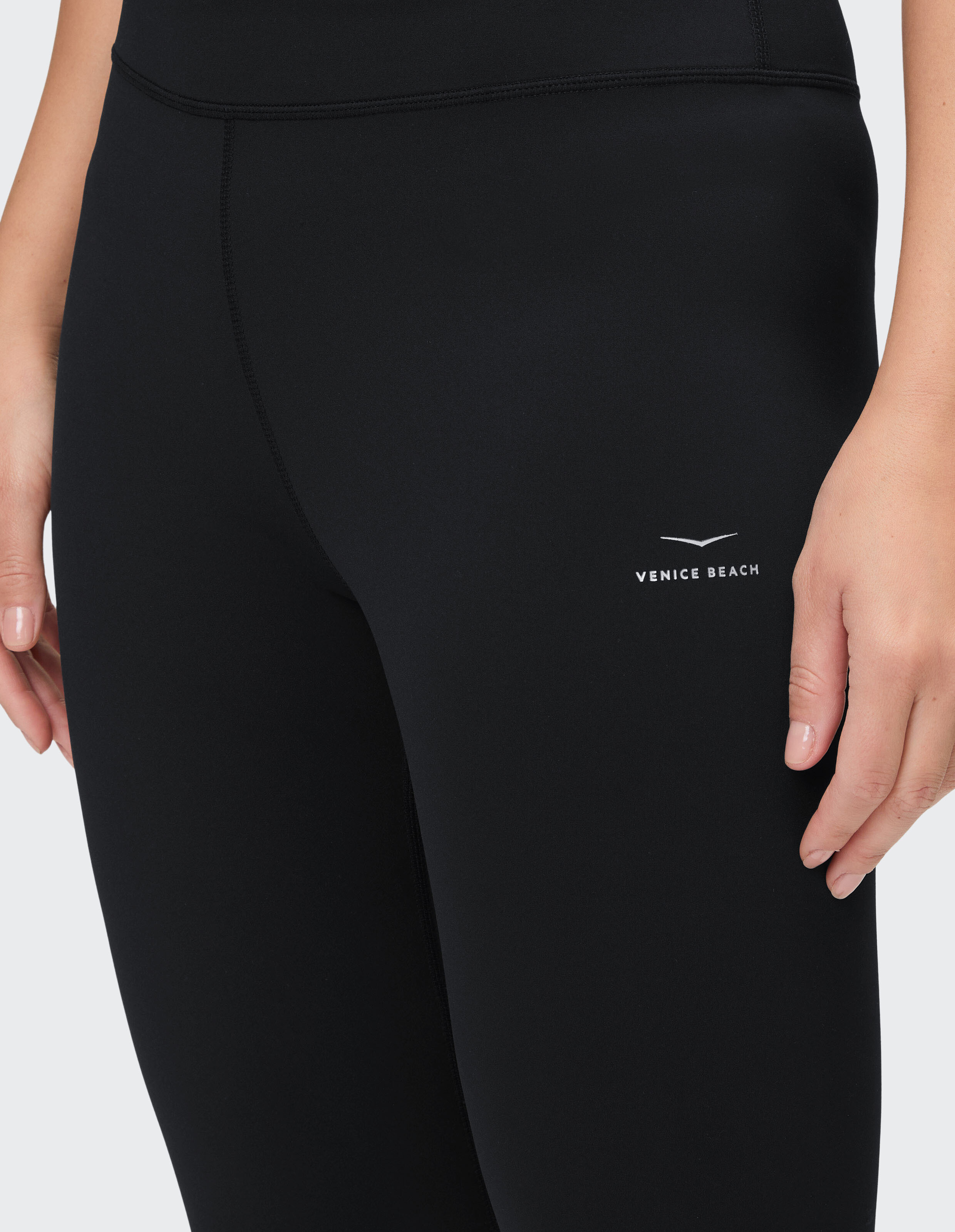 Nahaufnahme einer schwarzen Leggings mit Venice Beach-Logo, ideal für Freizeitkleidung.