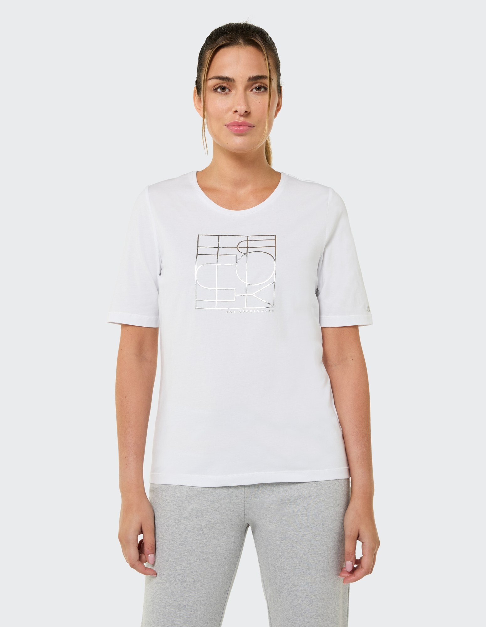 Lässiges weißes T-Shirt mit Grafikdruck, gepaart mit grauen Leggings.
