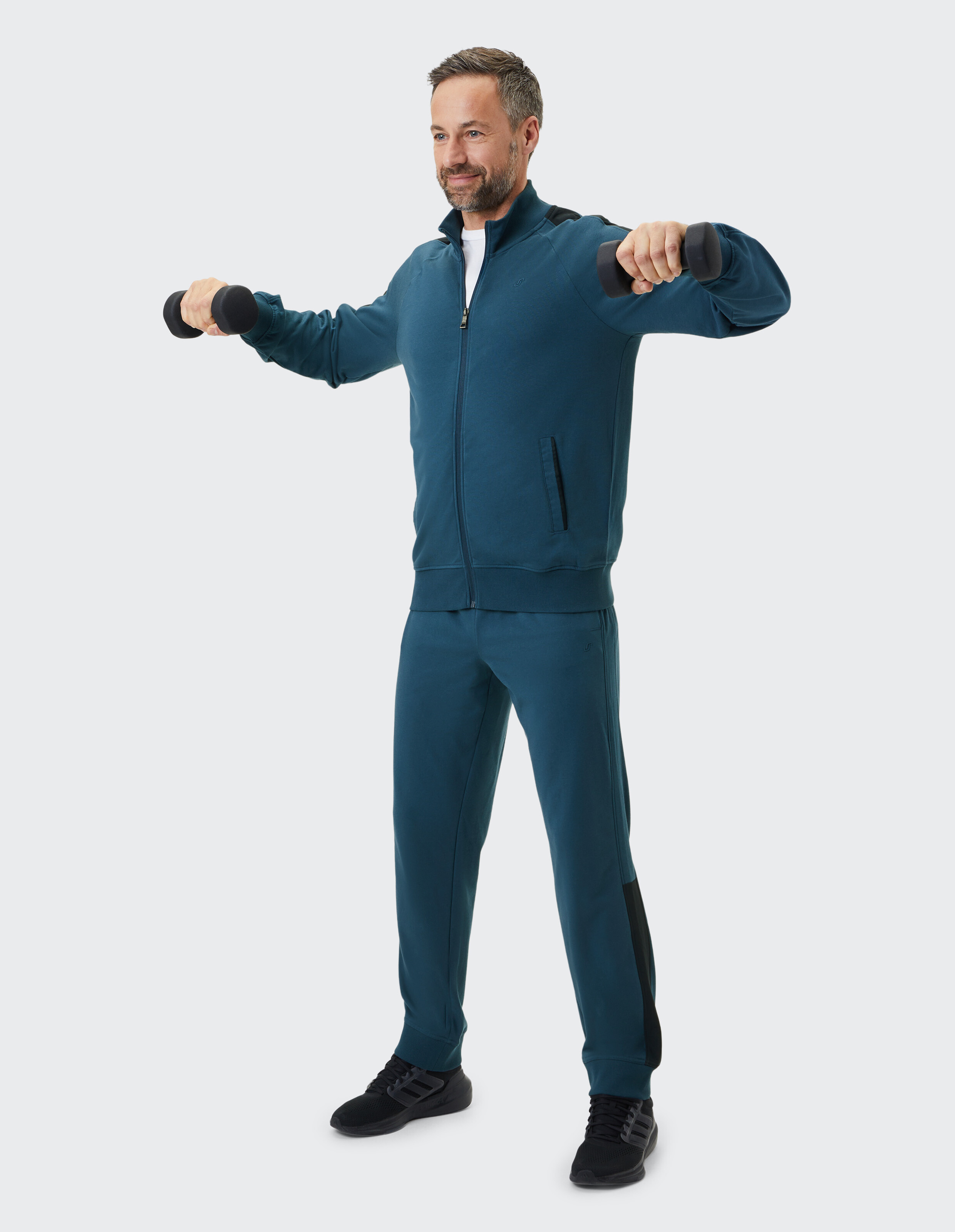 Blauer Trainingsanzug mit Reißverschlussjacke und langen Ärmeln, Hose mit elastischem Bund, schwarze Akzente an Schultern und Seiten.