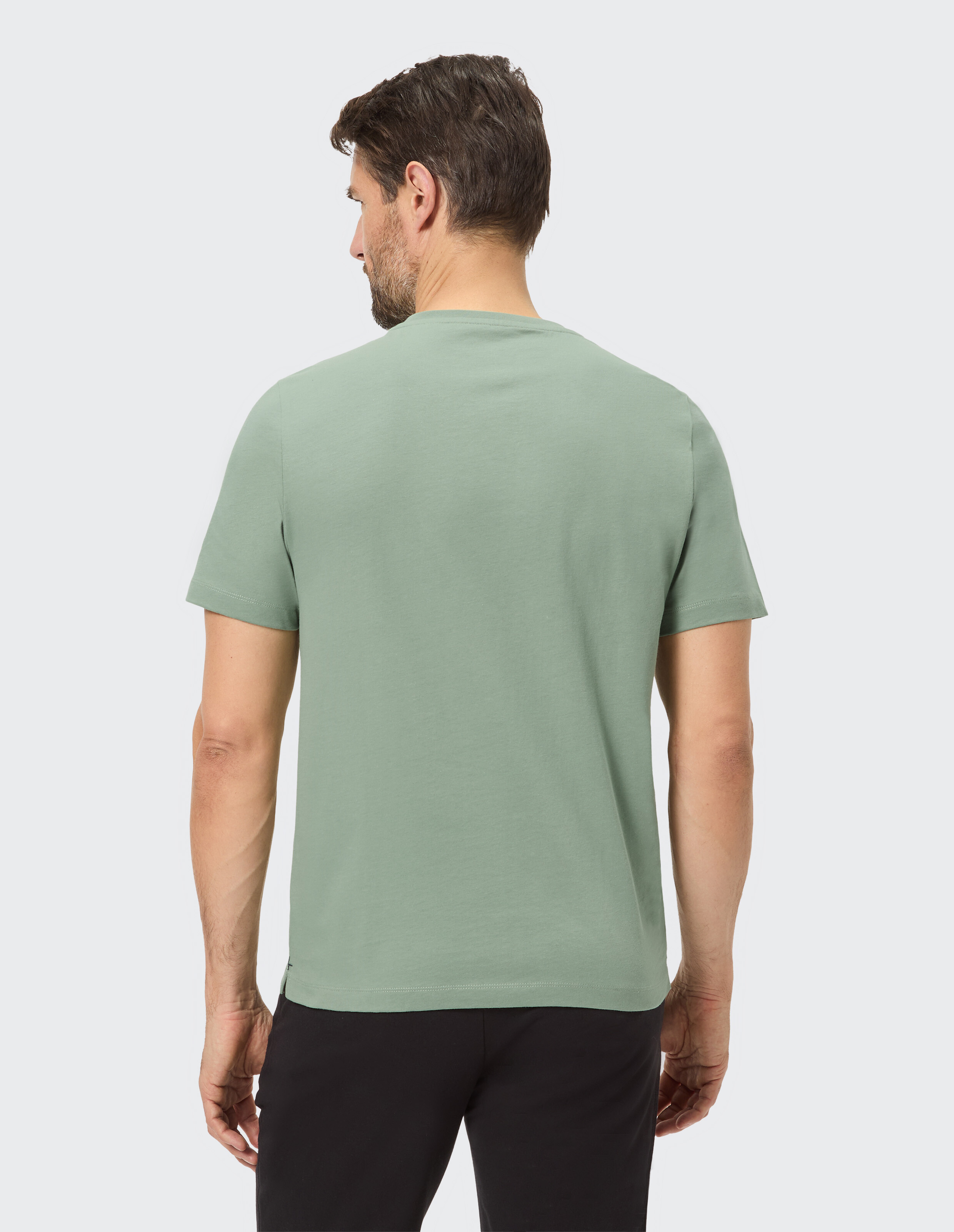 Rückansicht eines Mannes, der ein lässiges grünes T-Shirt trägt, perfekt für entspannte Ausflüge.