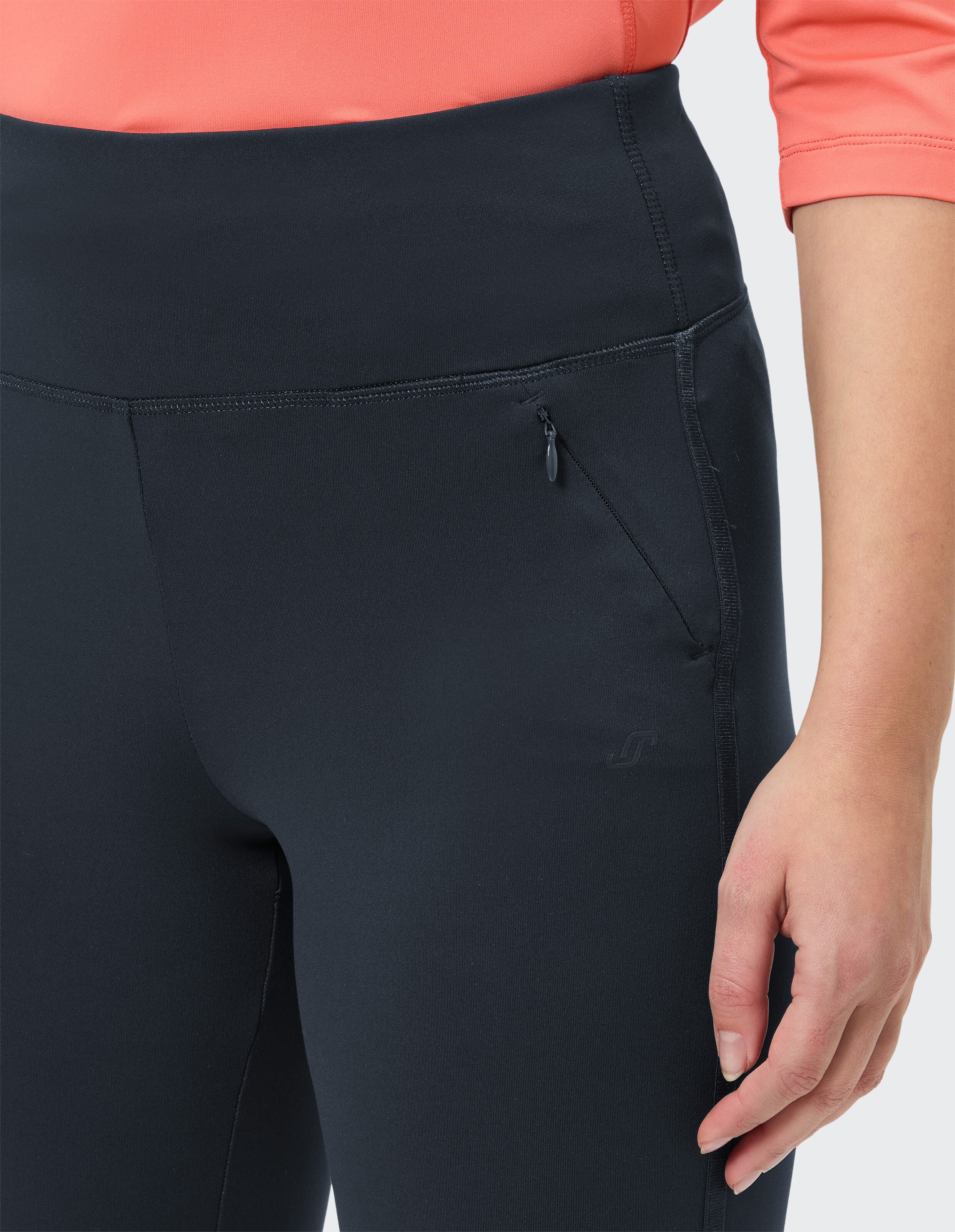 Weiße Sneakers aus Leder mit dicker Sohle, getragen zu dunkelblauen Hosen in leichter Stoffqualität, vor weißem Hintergrund.