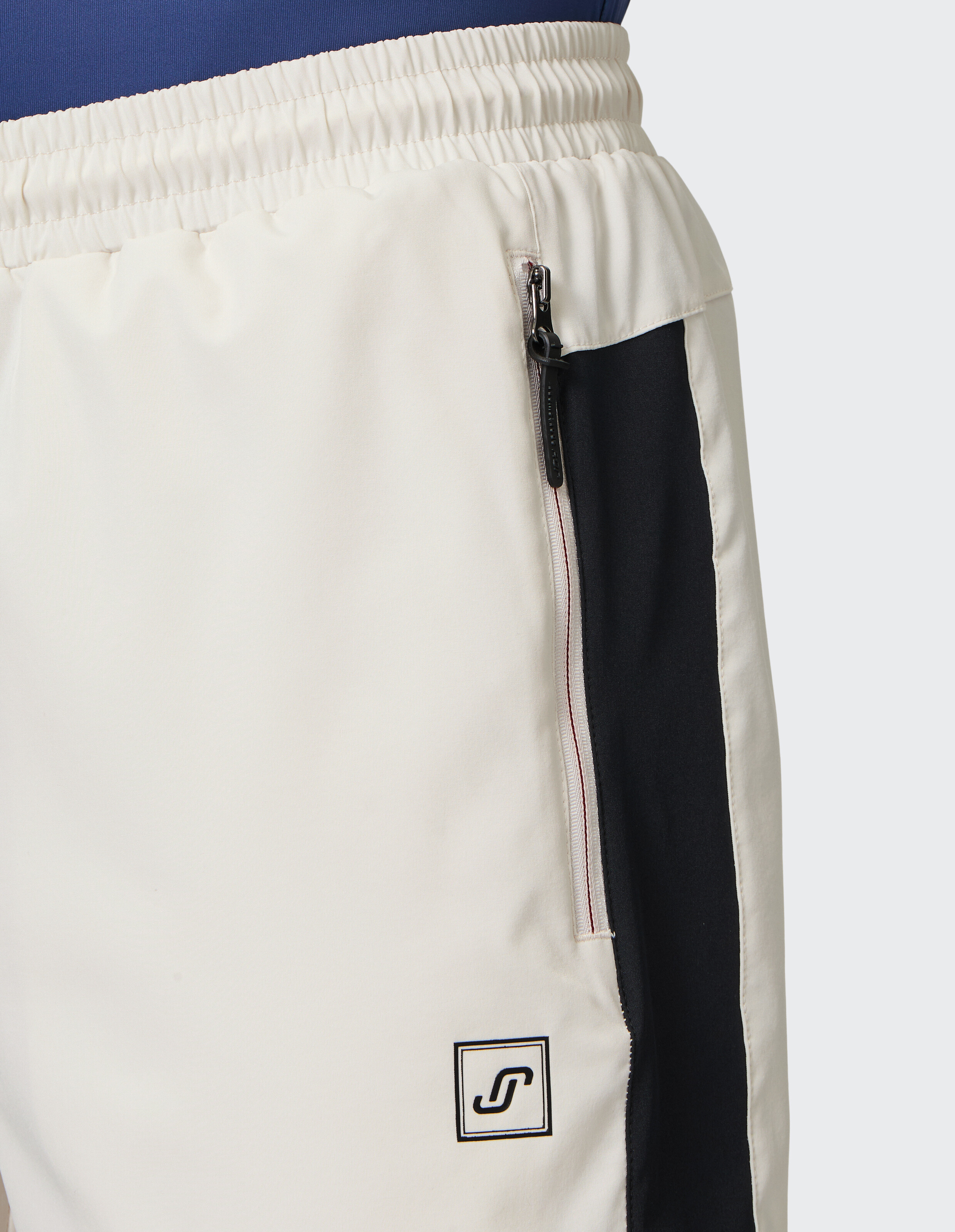 Nahaufnahme von cremefarbenen und marineblauen Freizeitshorts mit elastischem Bund und Reißverschlusstasche.