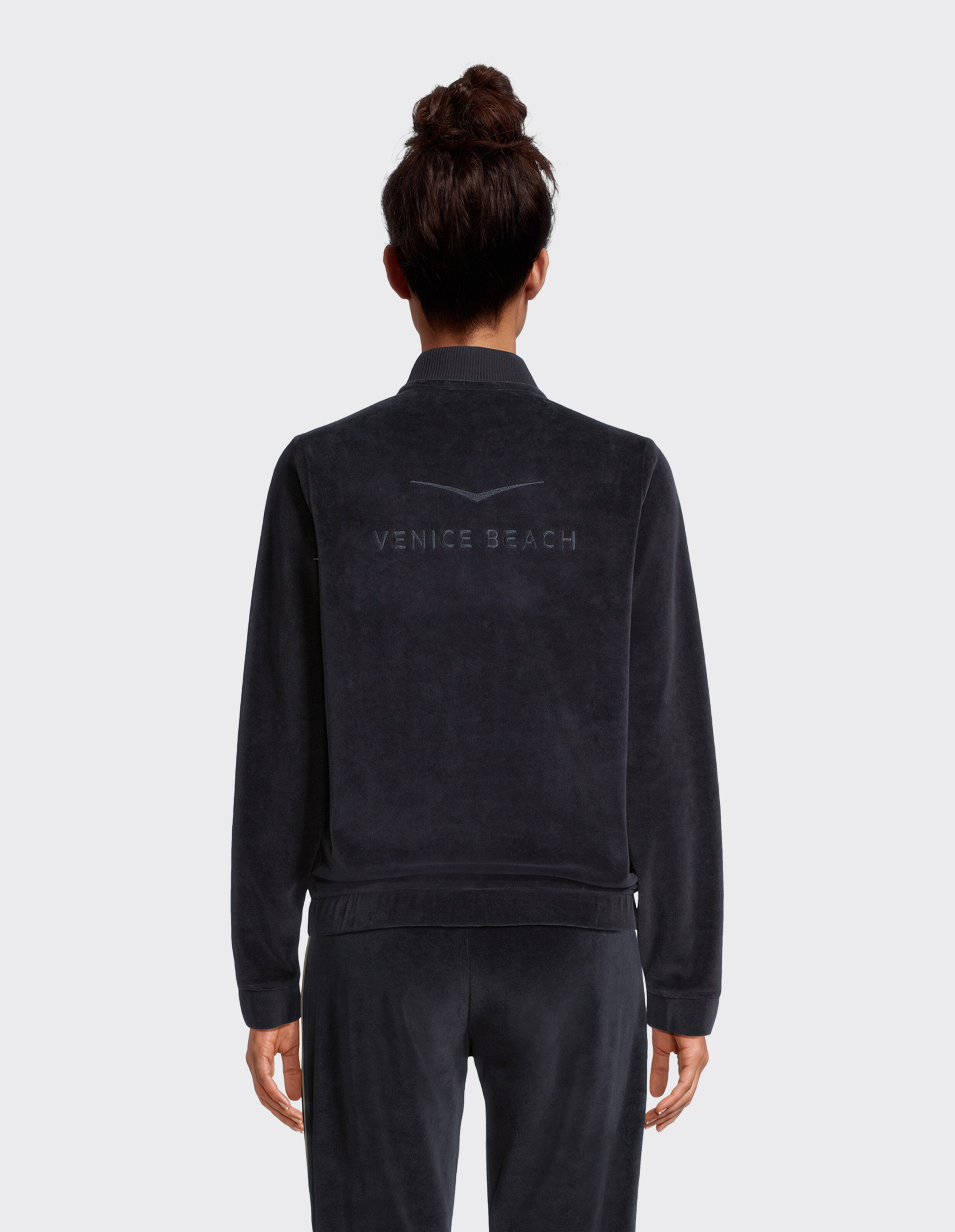 Rückansicht einer schwarzen Venice Beach Bessie Sweatjacke aus kuscheligem Veloursstoff.