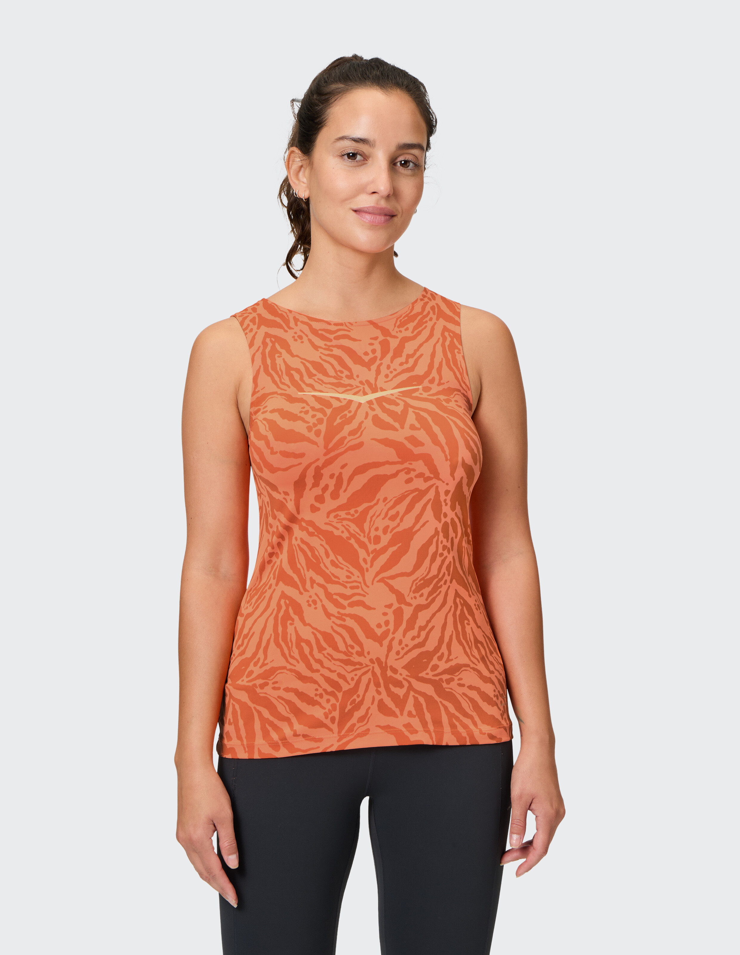 Frau trägt ein orangefarbenes ärmelloses Oberteil mit Tigermuster für lässige Loungewear.