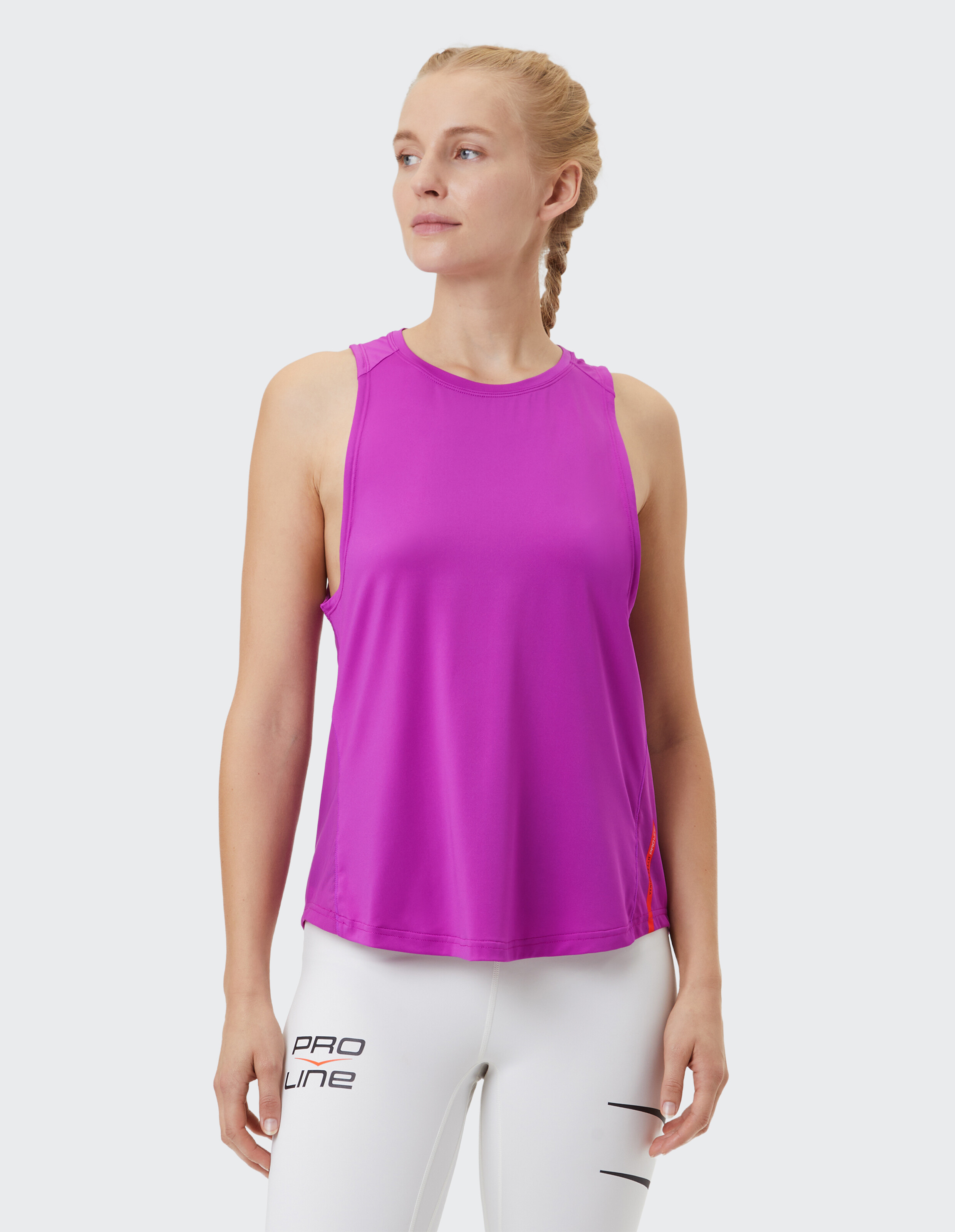 Frau in einem leuchtend rosa ärmellosen Oberteil, perfekt für Freizeitkleidung oder Workouts.