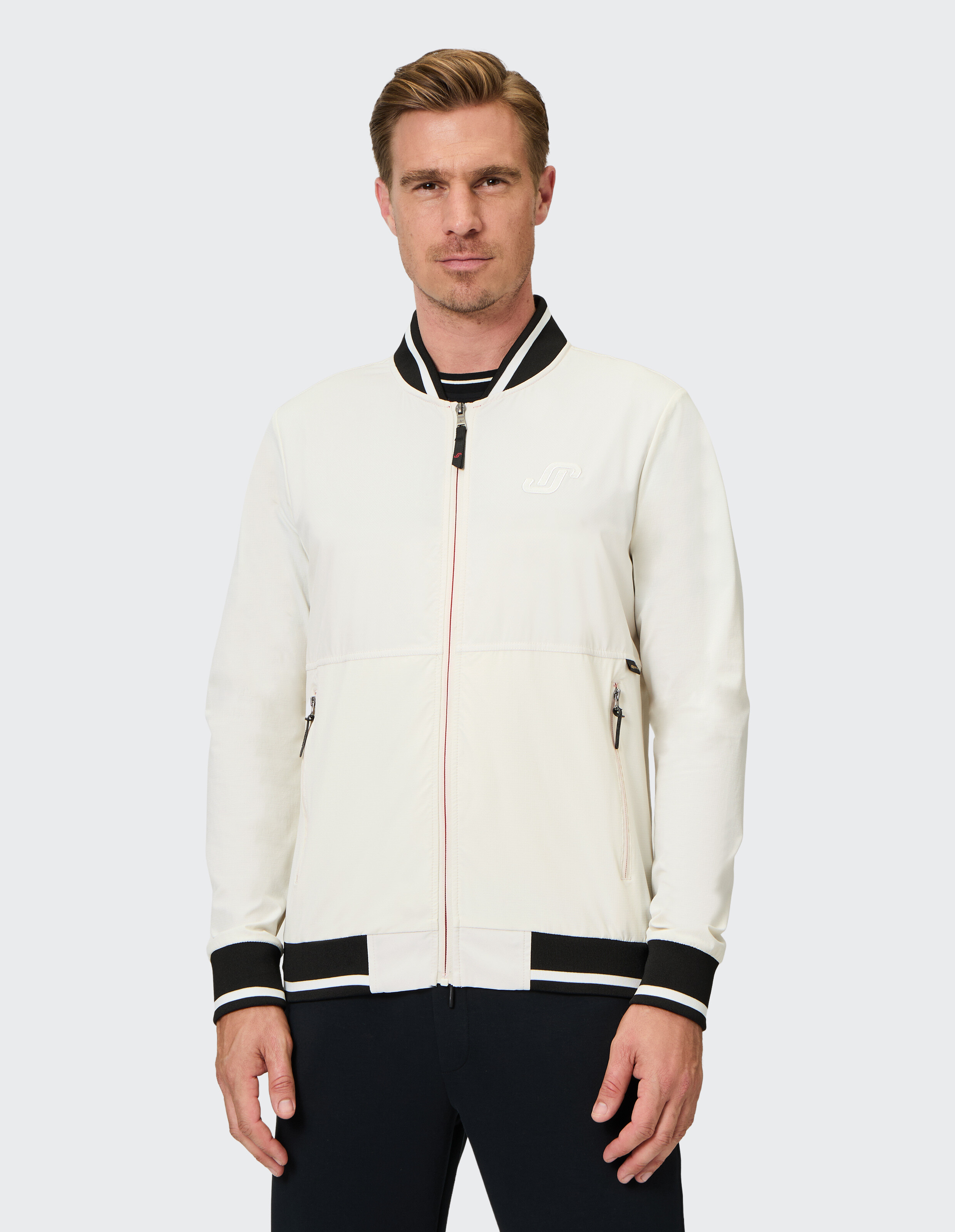 Leichte Herren-Bomberjacke in Creme mit schwarzen und weißen Akzenten.