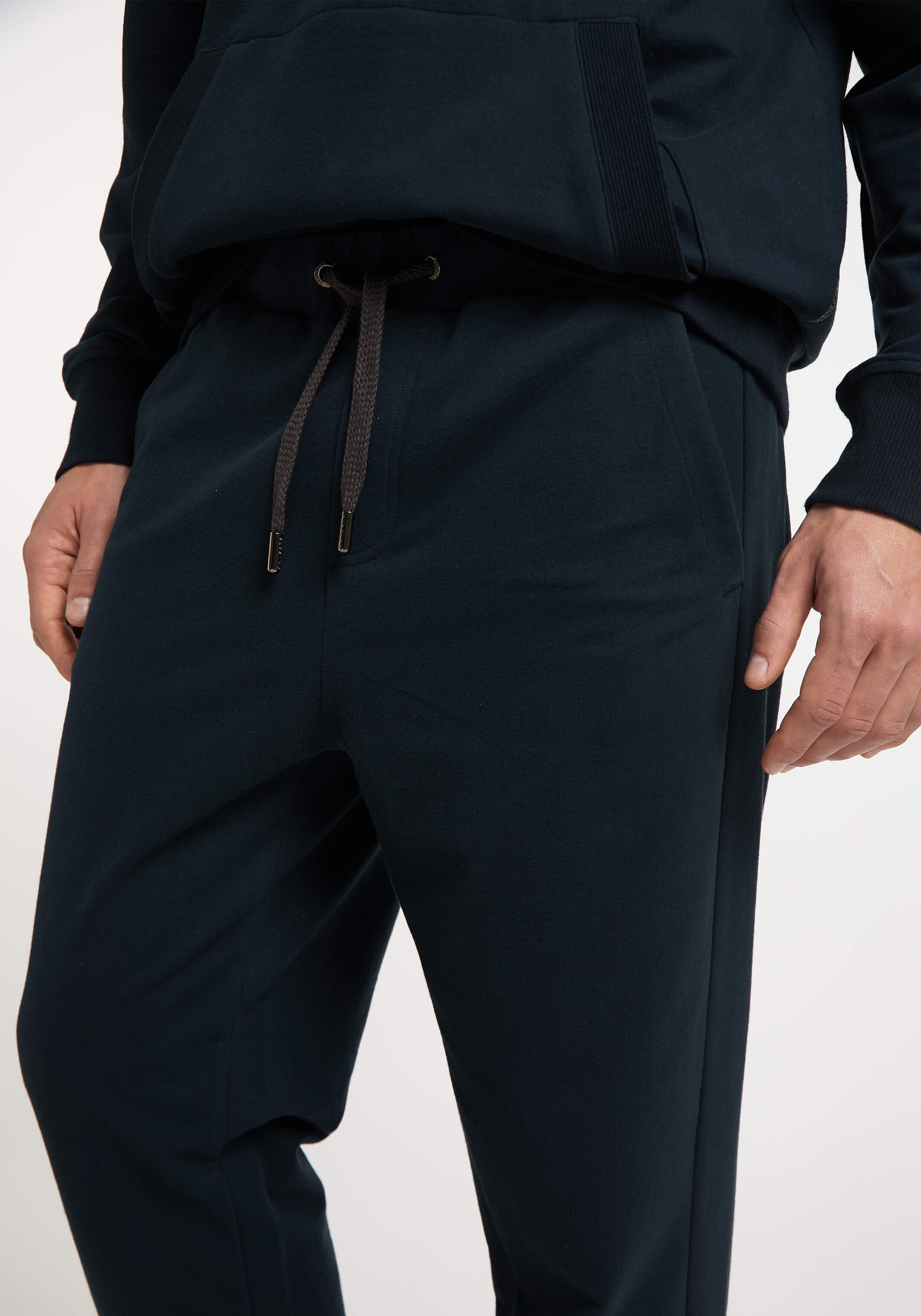 Nahaufnahme einer marineblauen Freizeit-Jogginghose mit verstellbarem Kordelzug in der Taille.