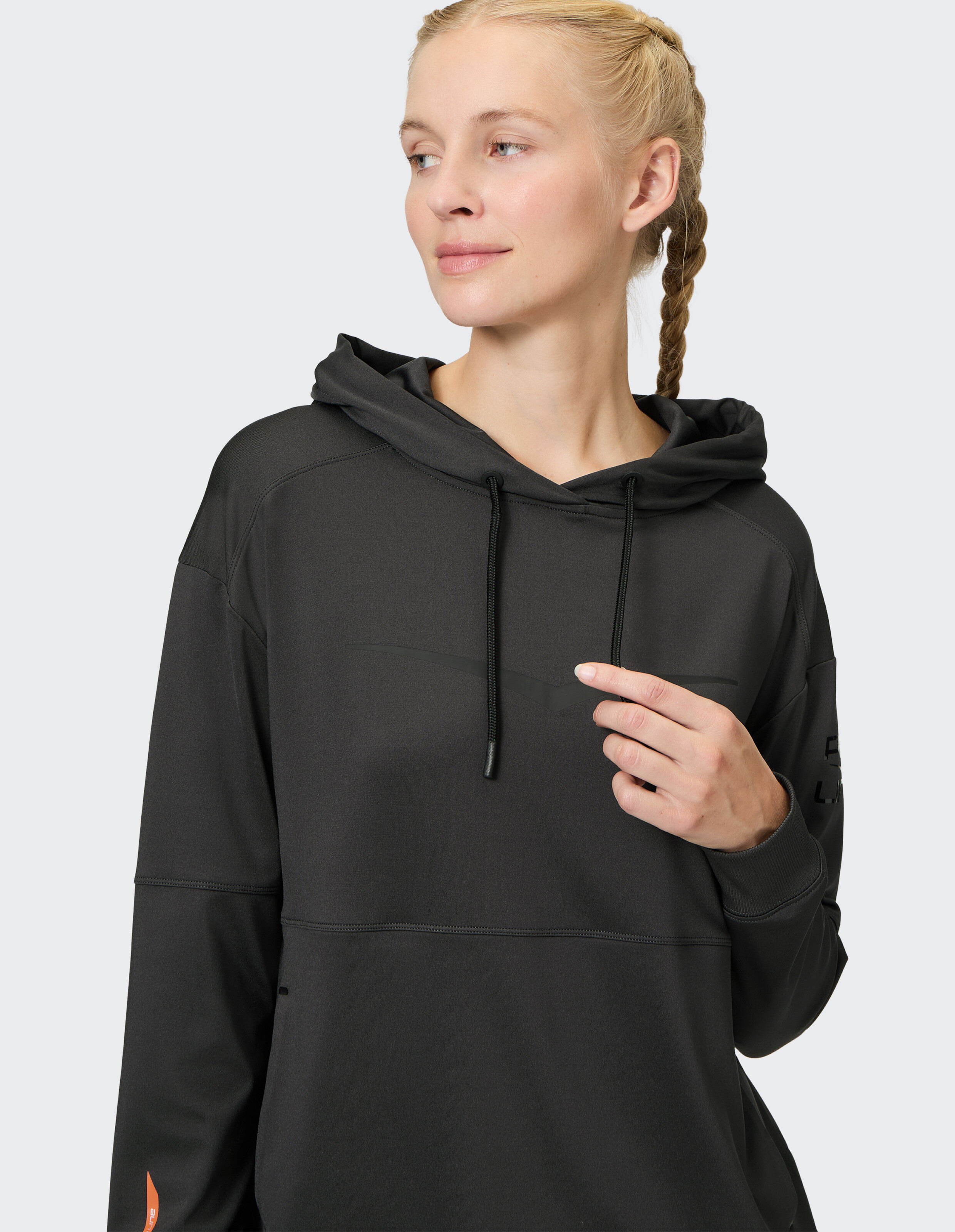 Frau trägt einen kuscheligen schwarzen Venice Beach Hoodie Birmingham für lässige Lounge-Kleidung.