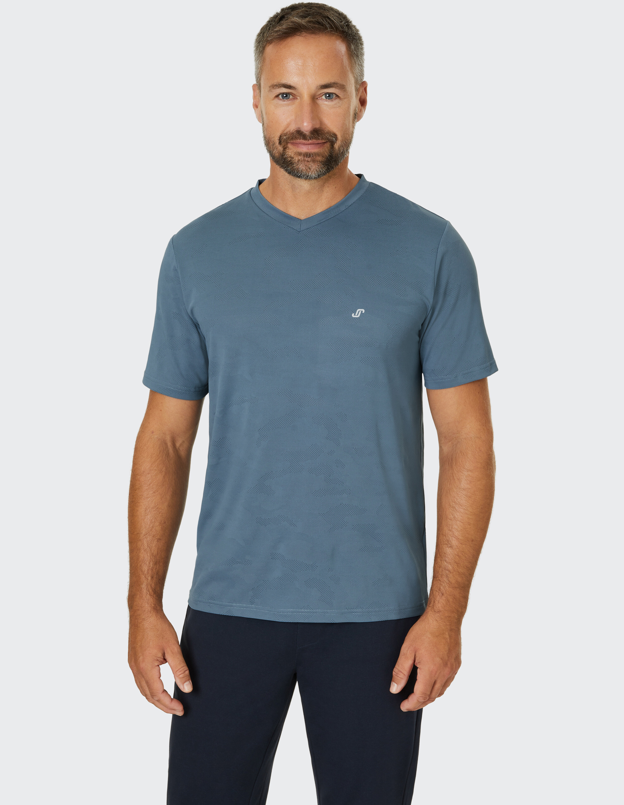 Blaues T-Shirt mit V-Ausschnitt und kurzen Ärmeln, dezentem Muster und kleinem Logo auf der Brust.