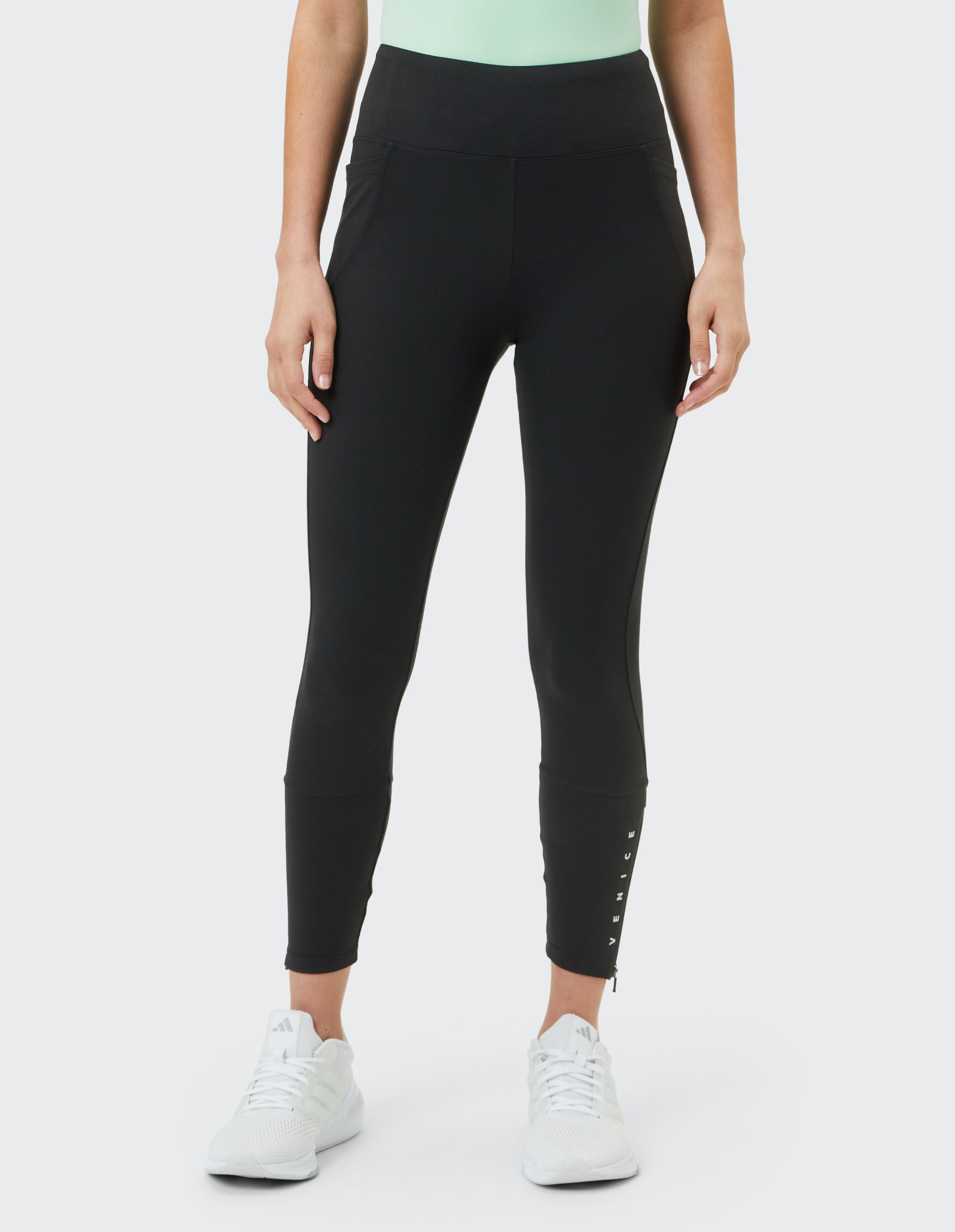 Schwarze Leggings mit hohem Bund, Seitentaschen und Reißverschlussdetail, perfekt für Freizeitkleidung.