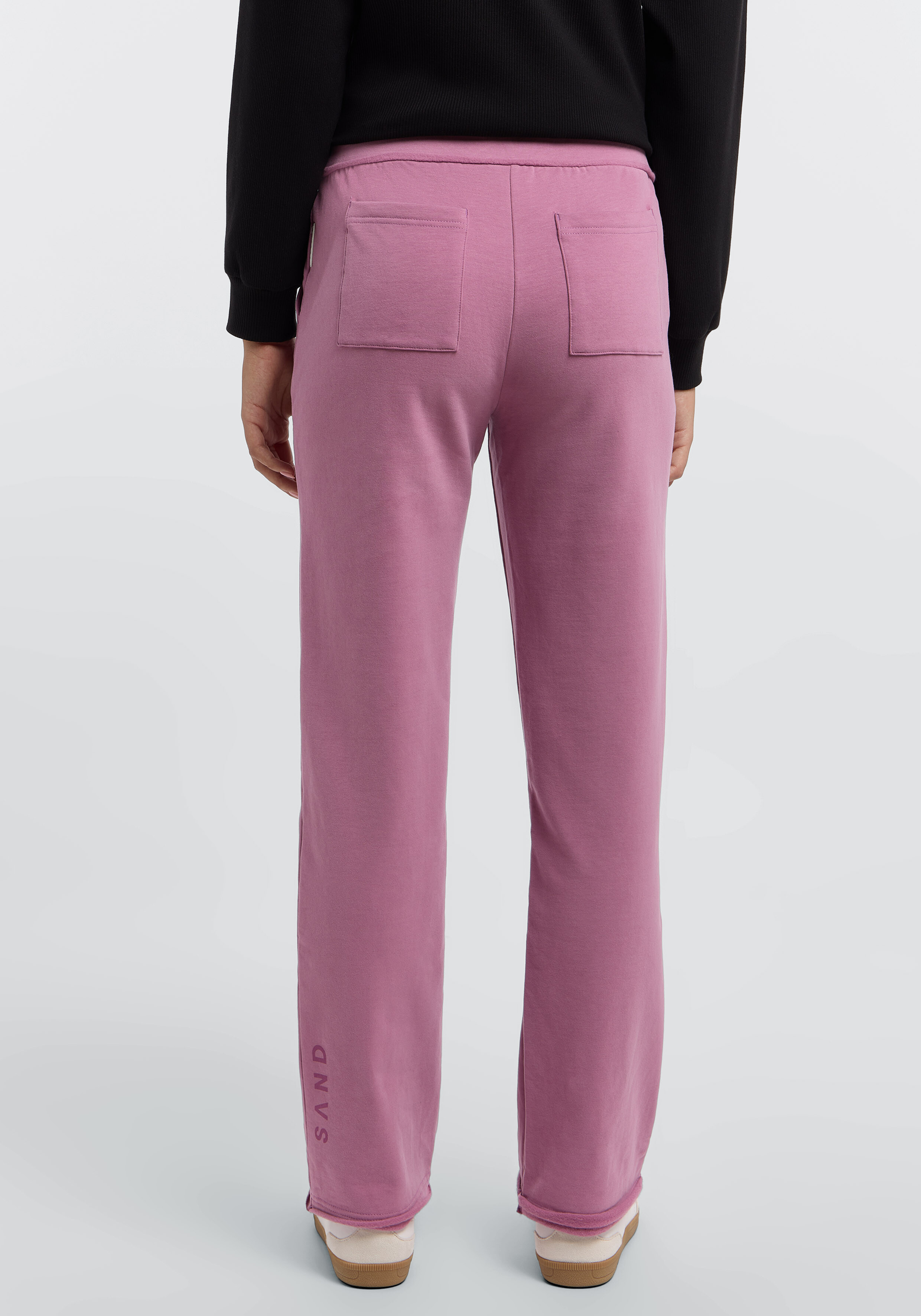 Rückansicht einer gemütlichen malvenfarbenen Lounge-Hose mit Taschen und dezentem Branding.